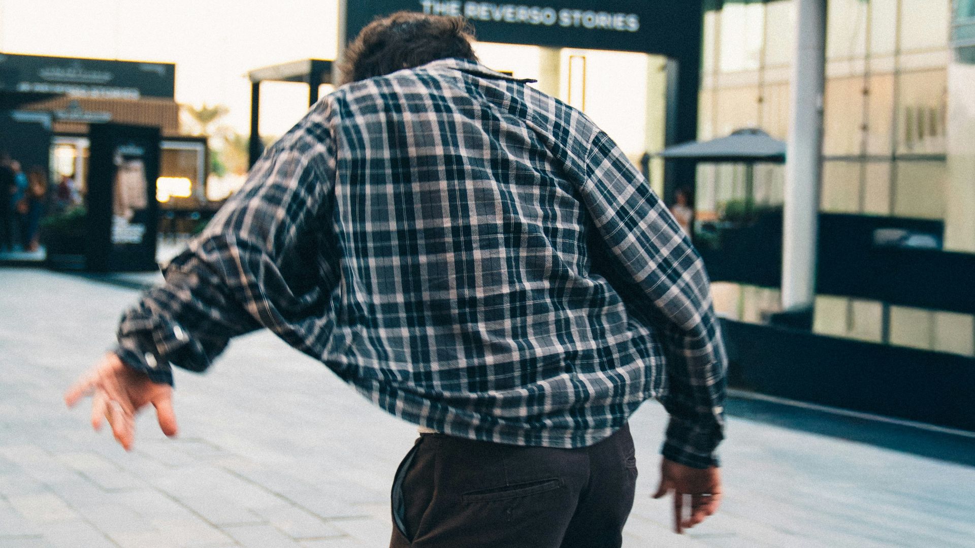 Young man skateboarding in urban plaza