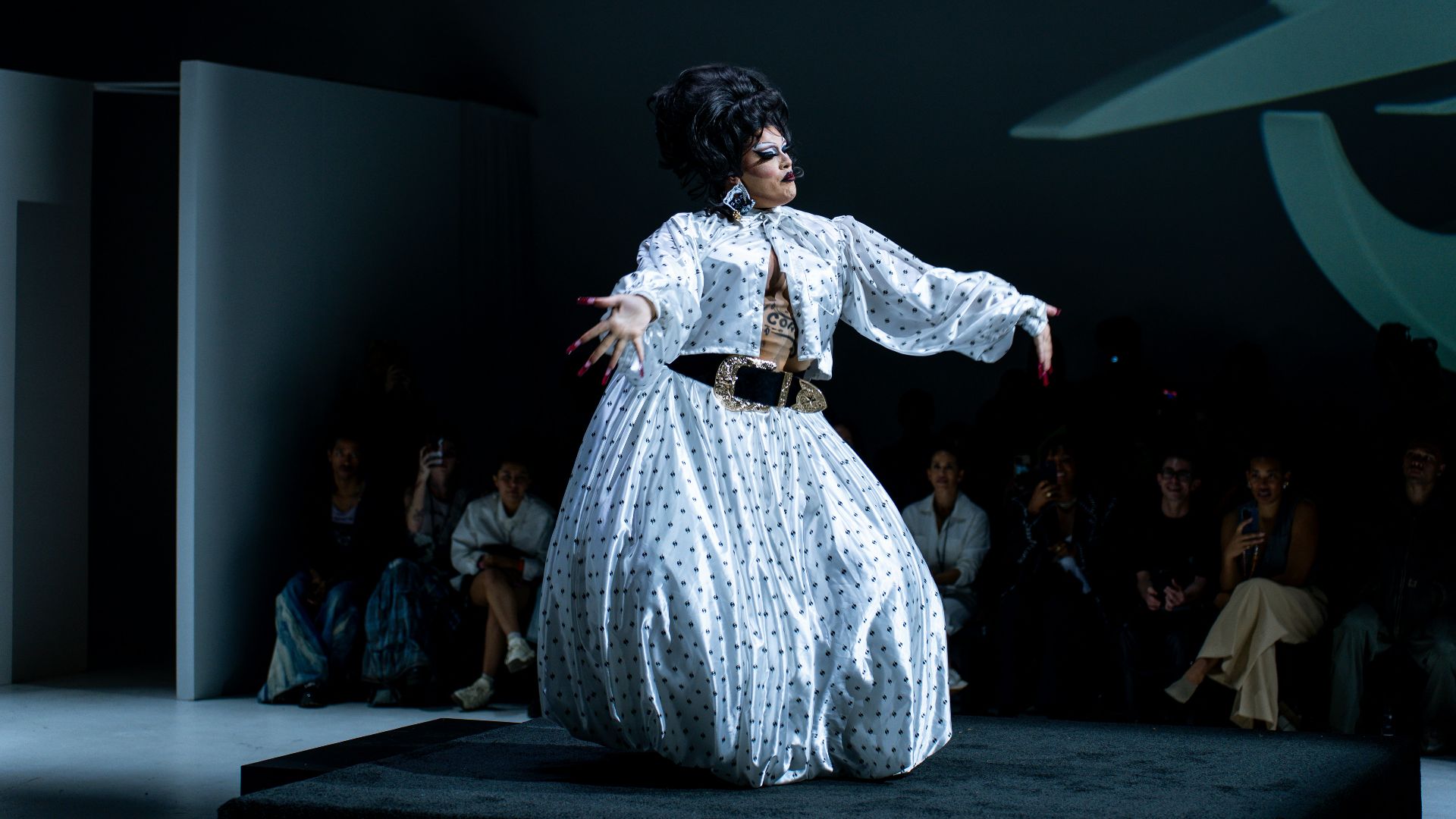 a woman in a white dress on a runway