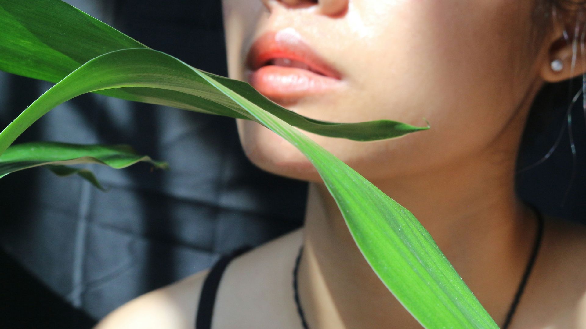 a woman with red lipstick and a green plant