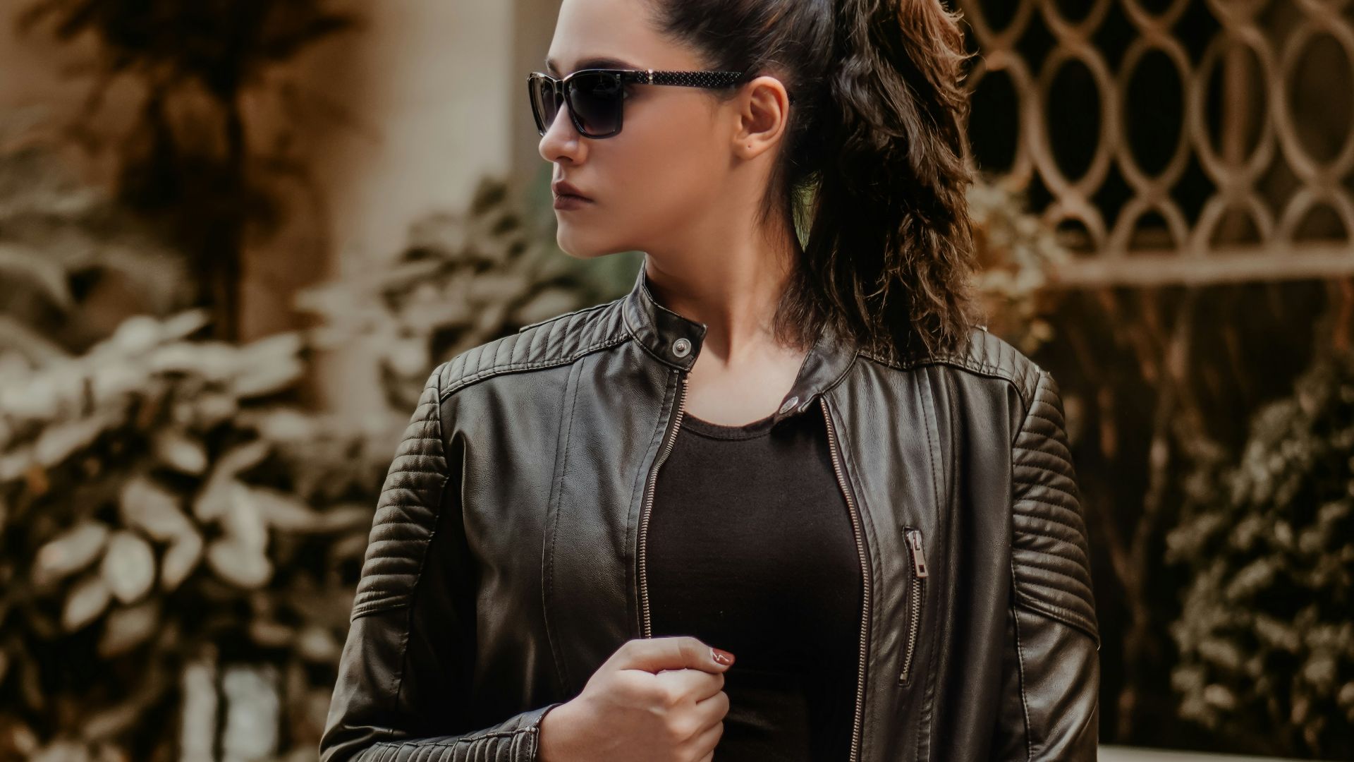 woman in black leather jacket wearing black sunglasses
