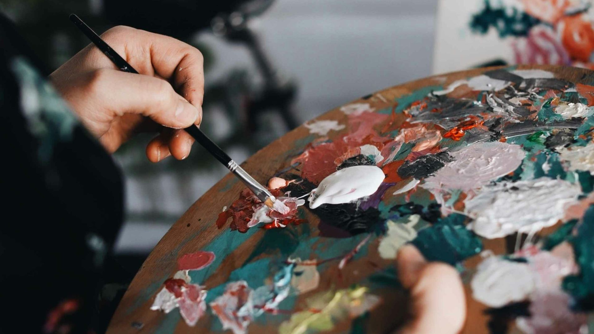 person holding paint brush while painting