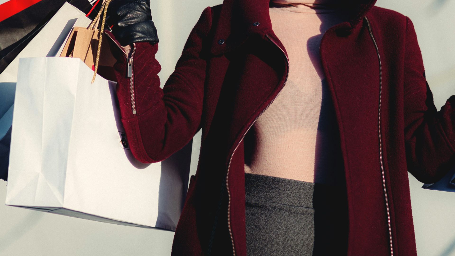 photo of woman holding white and black paper bags