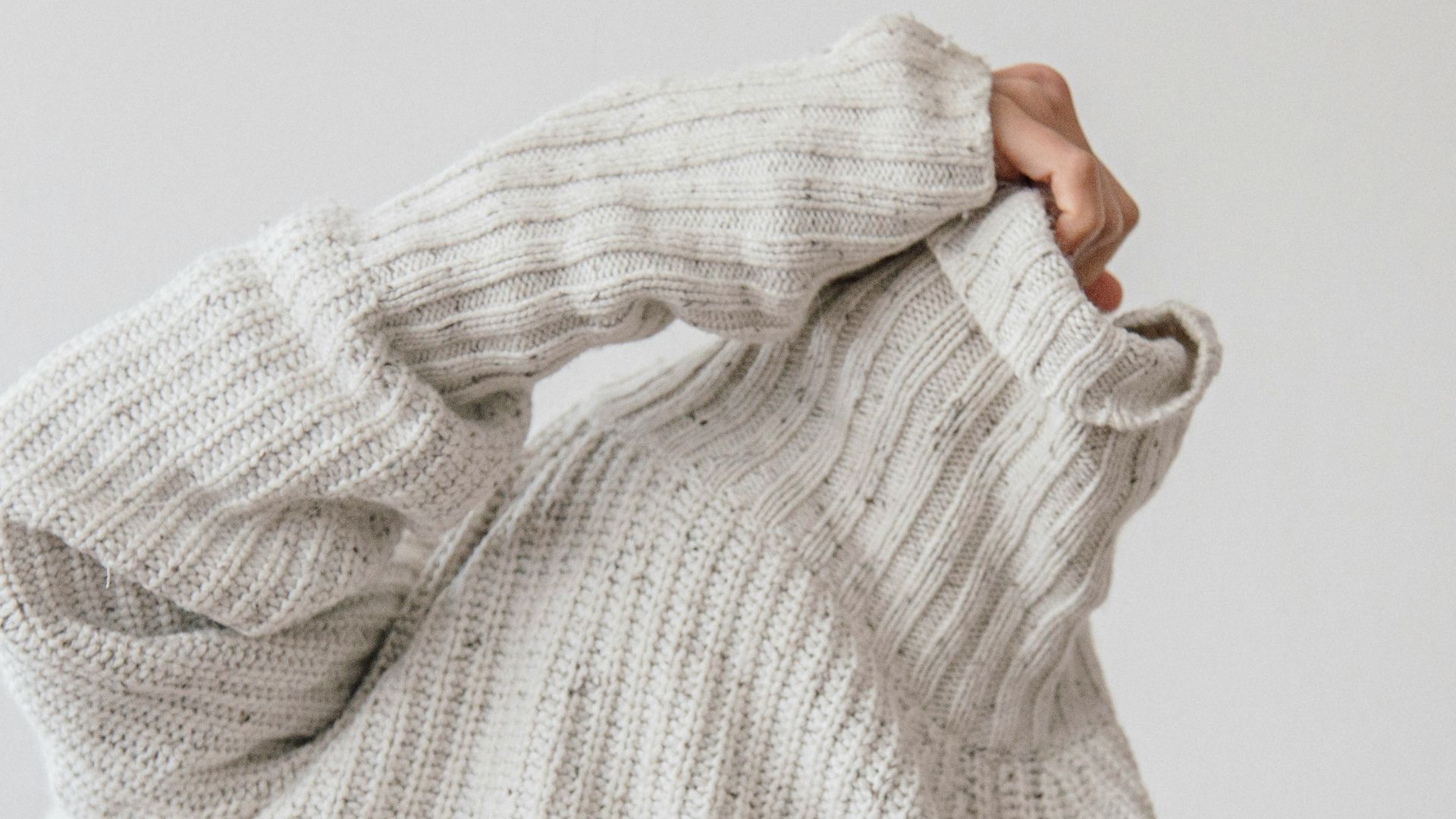 person wearing grey knit sweater