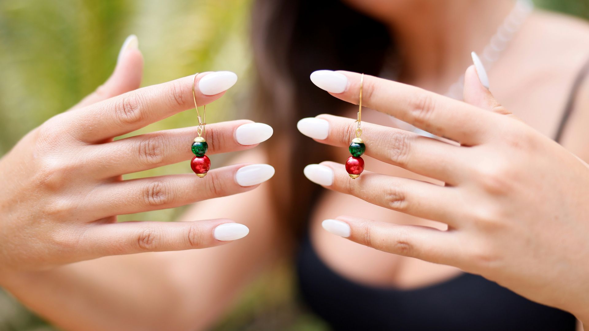 a woman wearing a black top holding a red and green ring