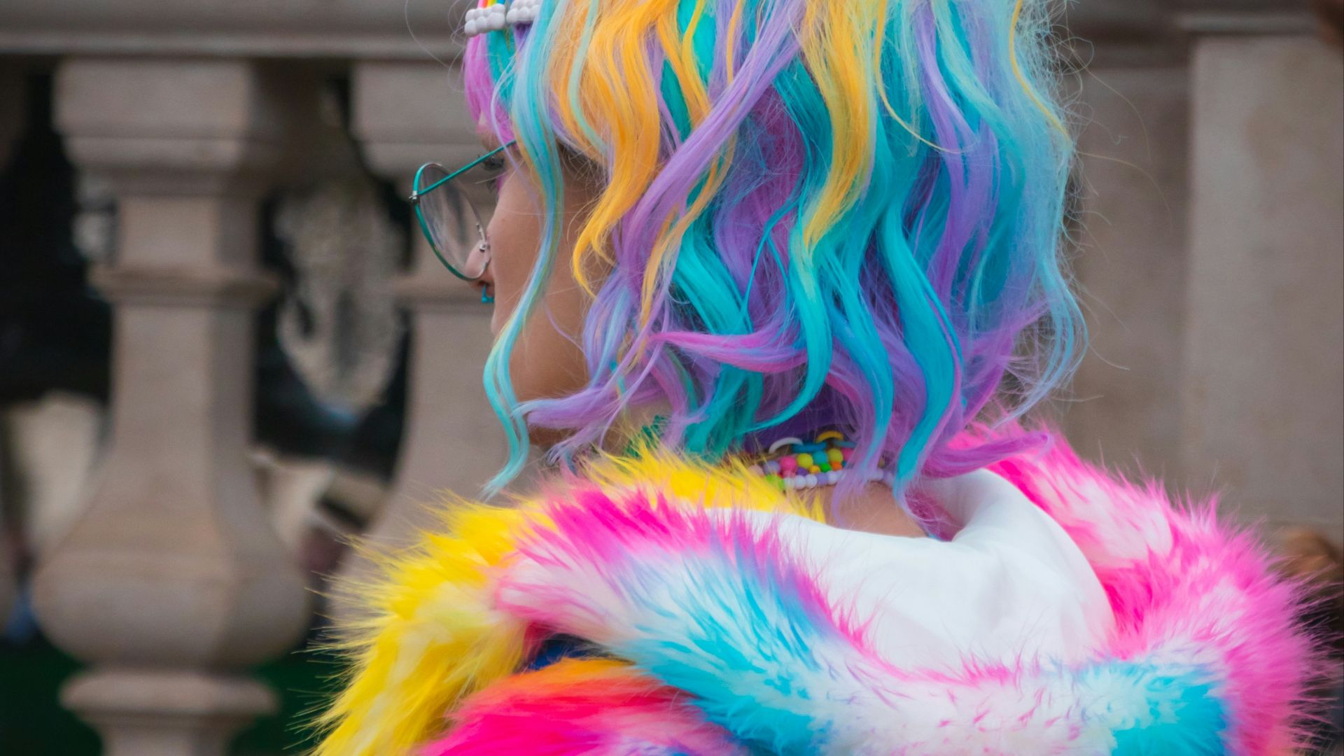 selective color photography of woman wearing blue, yellow, and pink coat and hair