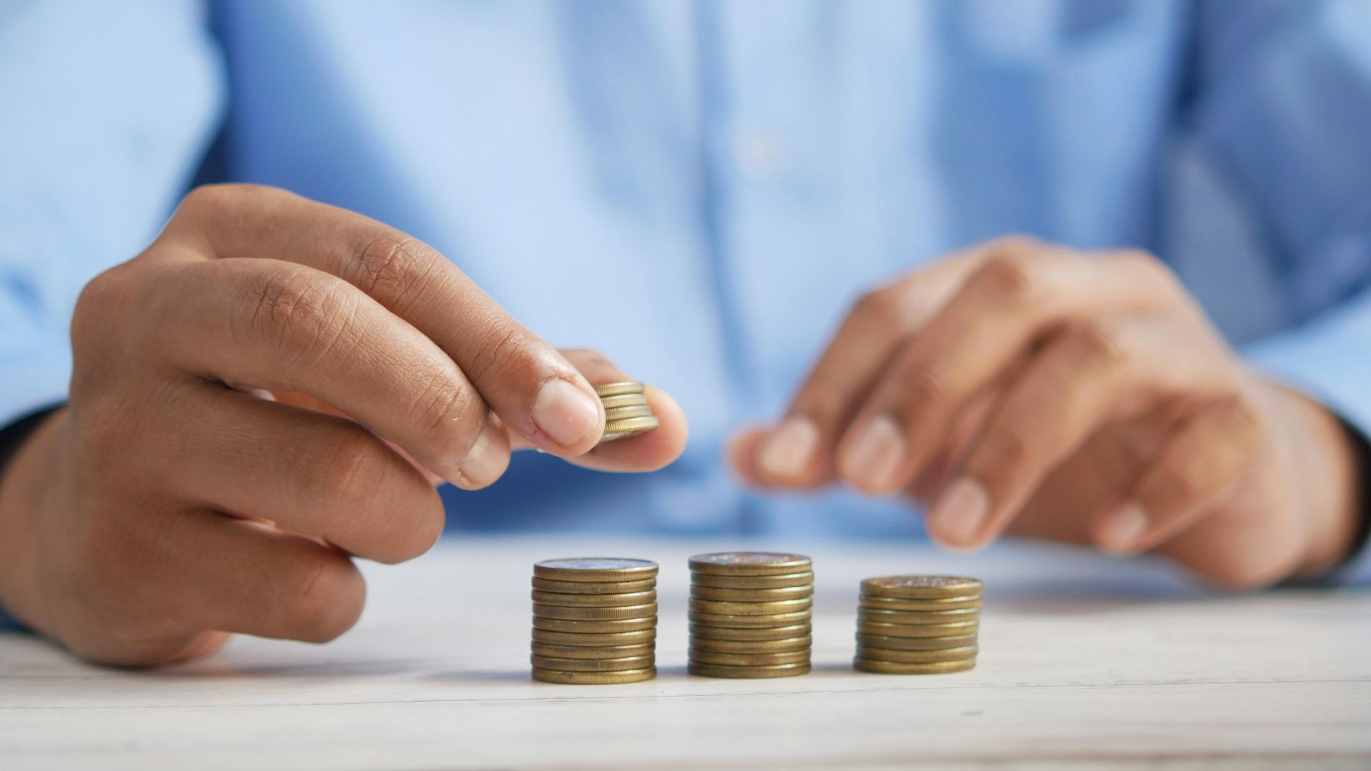 a person stacking coins on top of a table