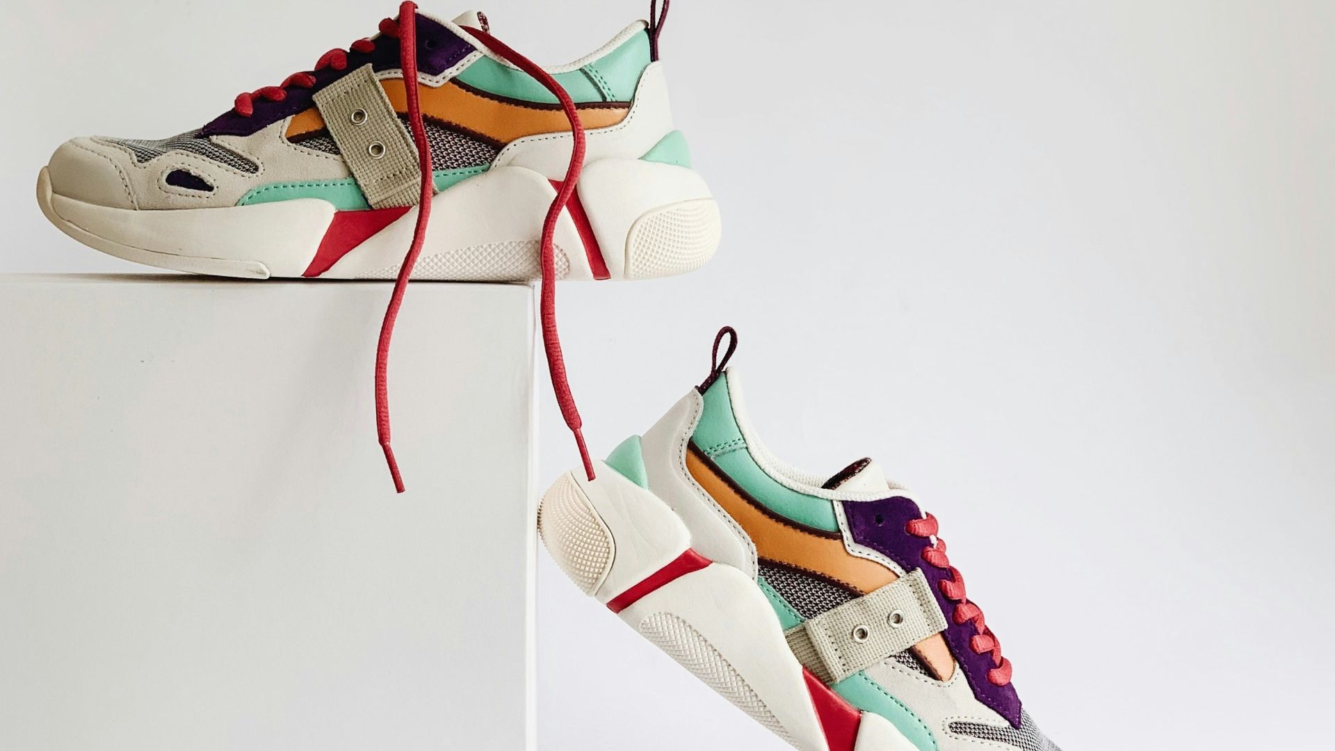 pair of white-and-orange athletic shoes on white box