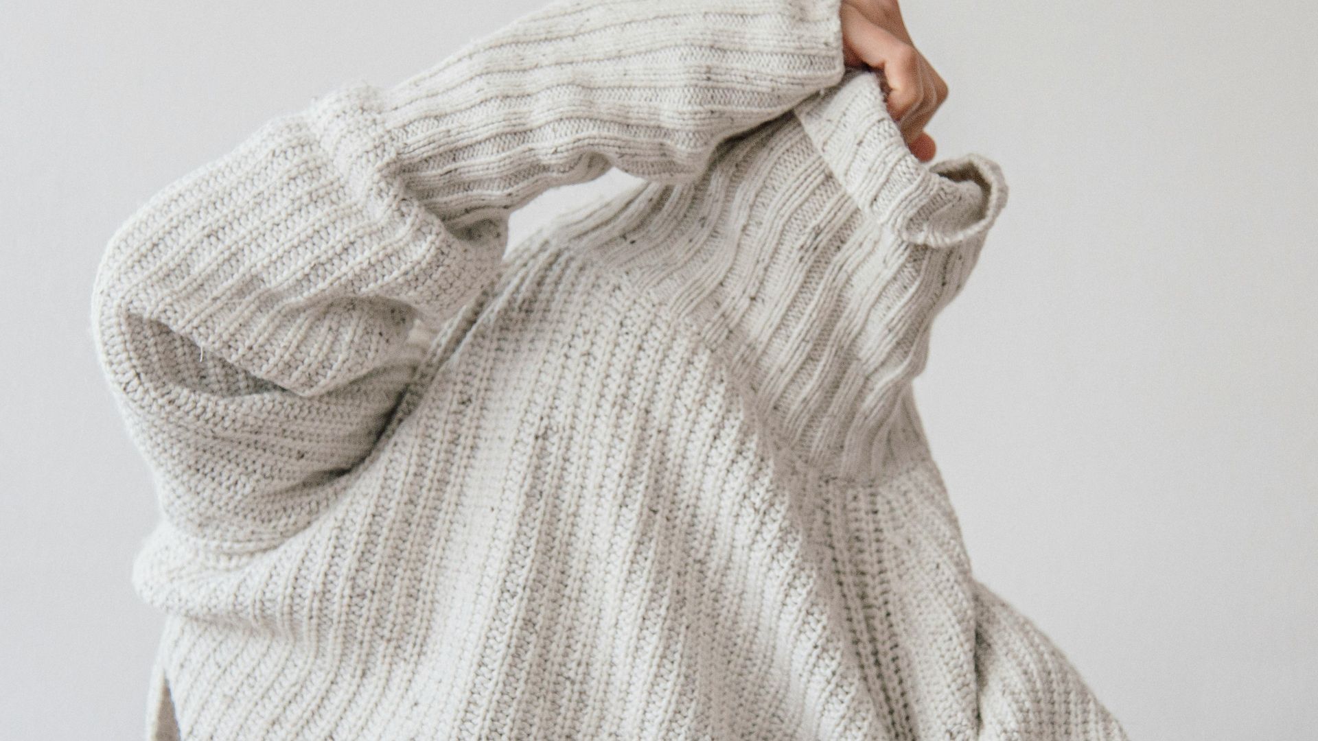 person wearing grey knit sweater