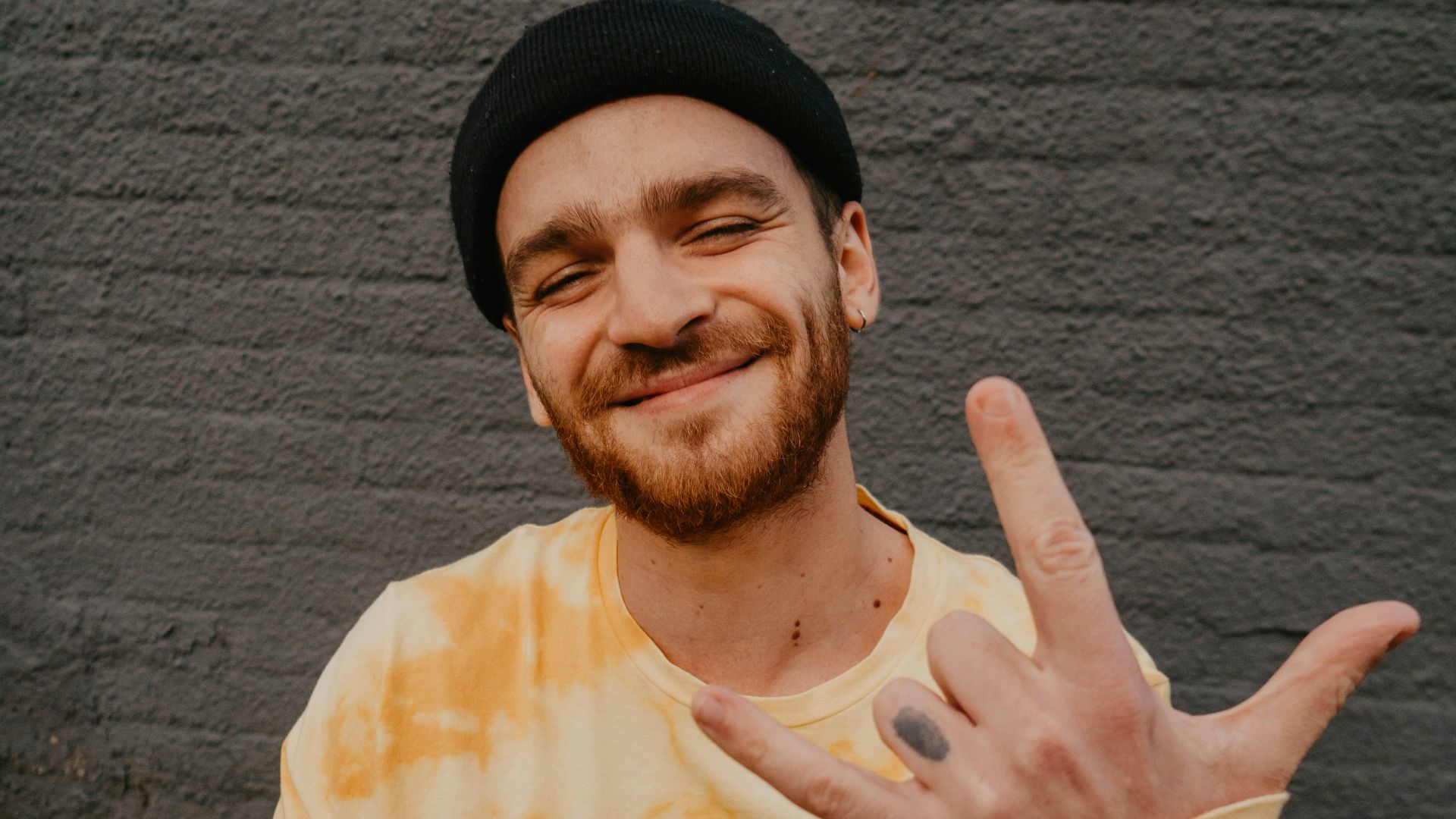 man in yellow crew neck shirt and black knit cap