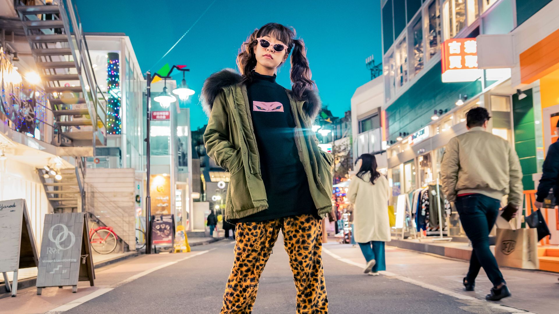 woman in green jacket stands and pose on street