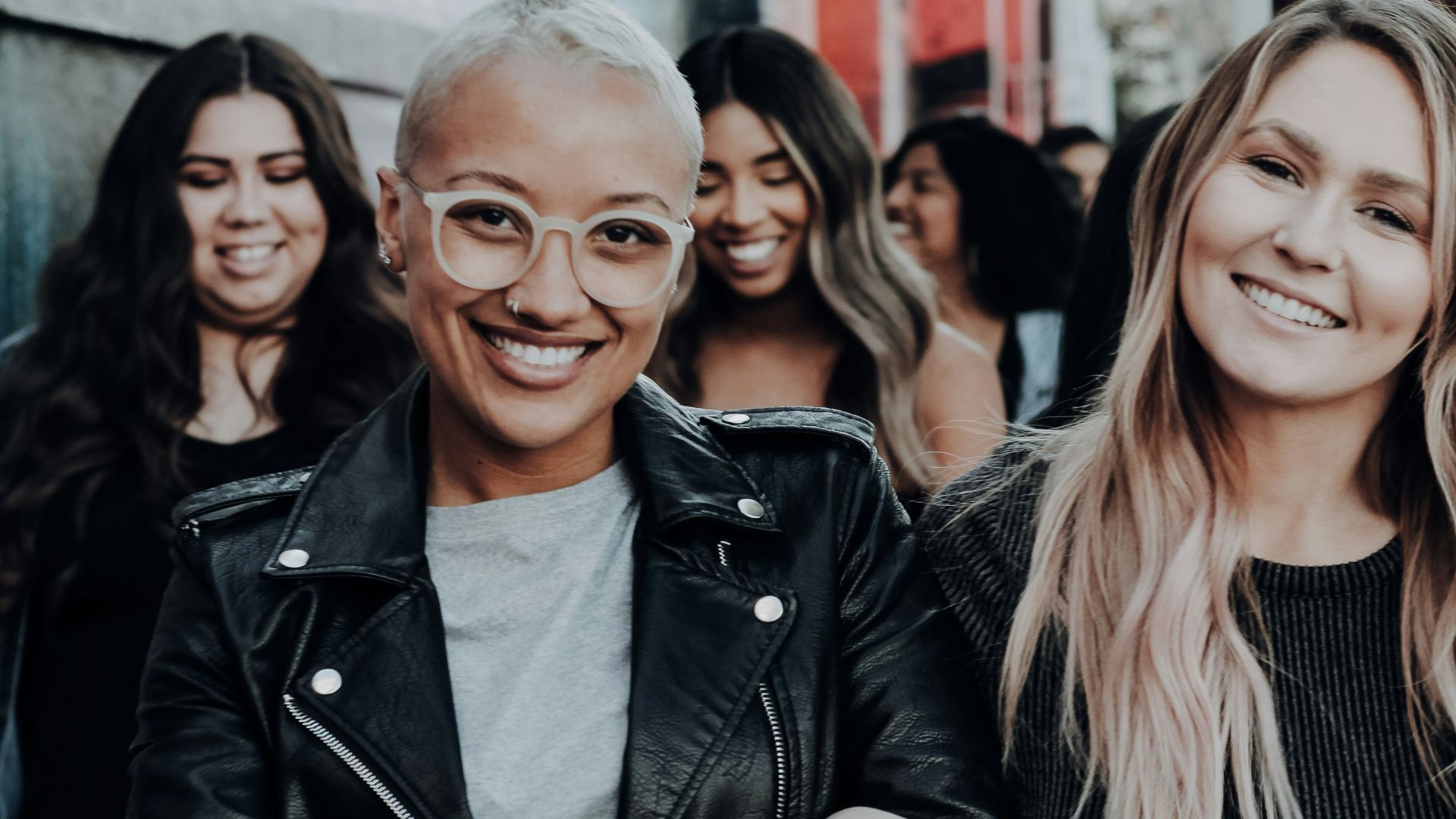 man in black leather jacket beside woman in black and white stripe shirt