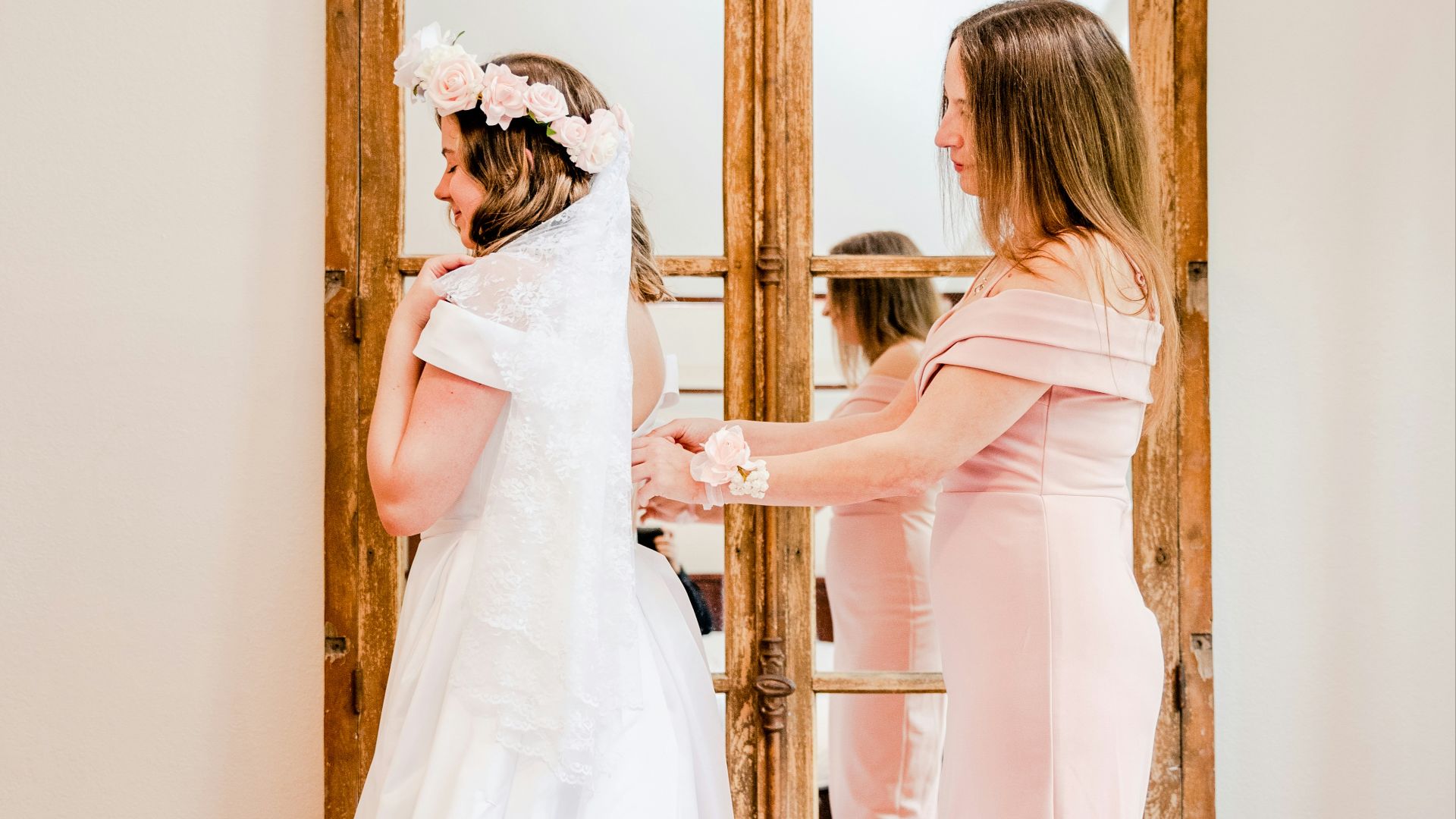 a woman in a wedding dress standing in front of a mirror