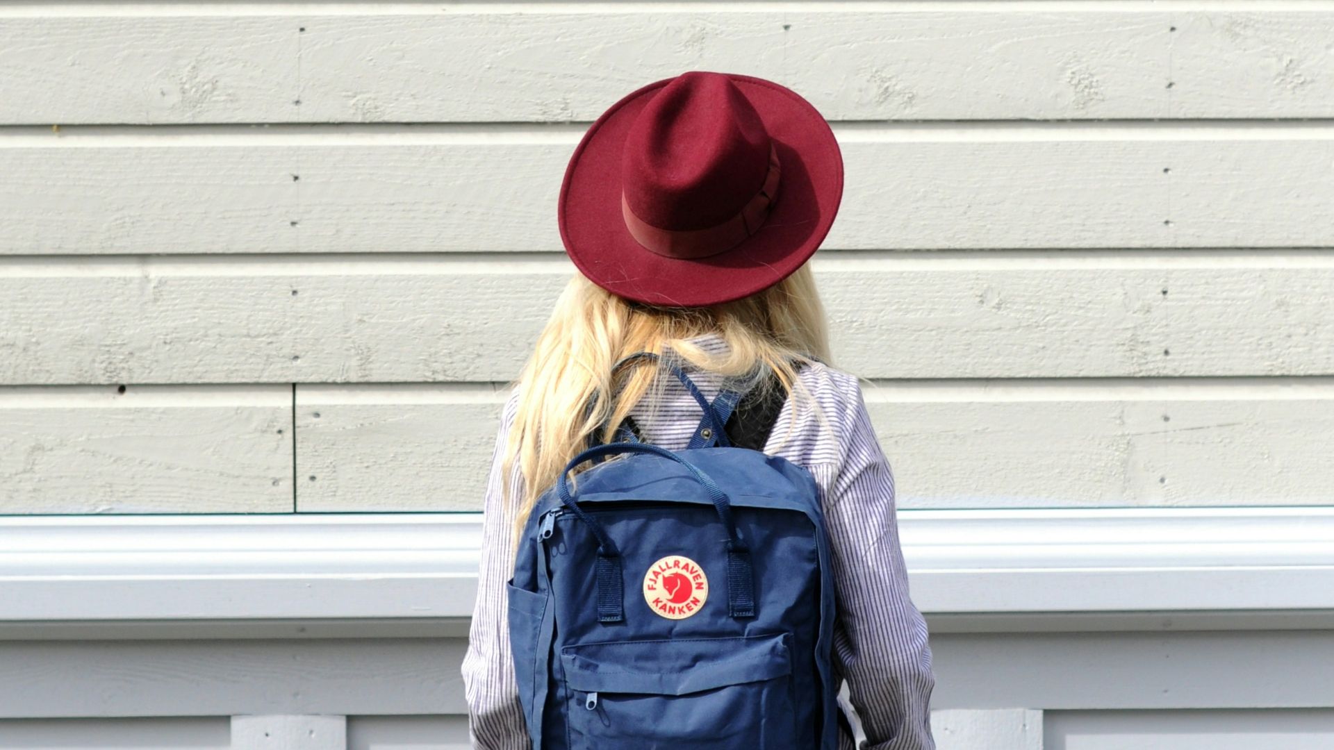 woman standing in front of wooden wall