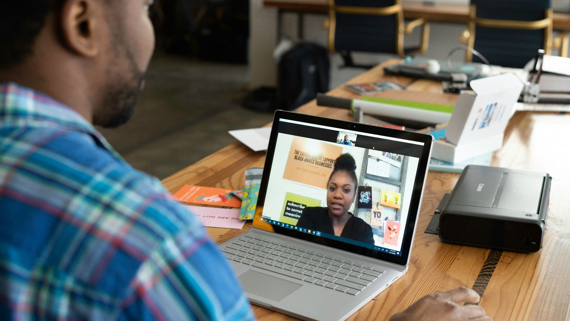 man in blue and white plaid shirt using macbook pro