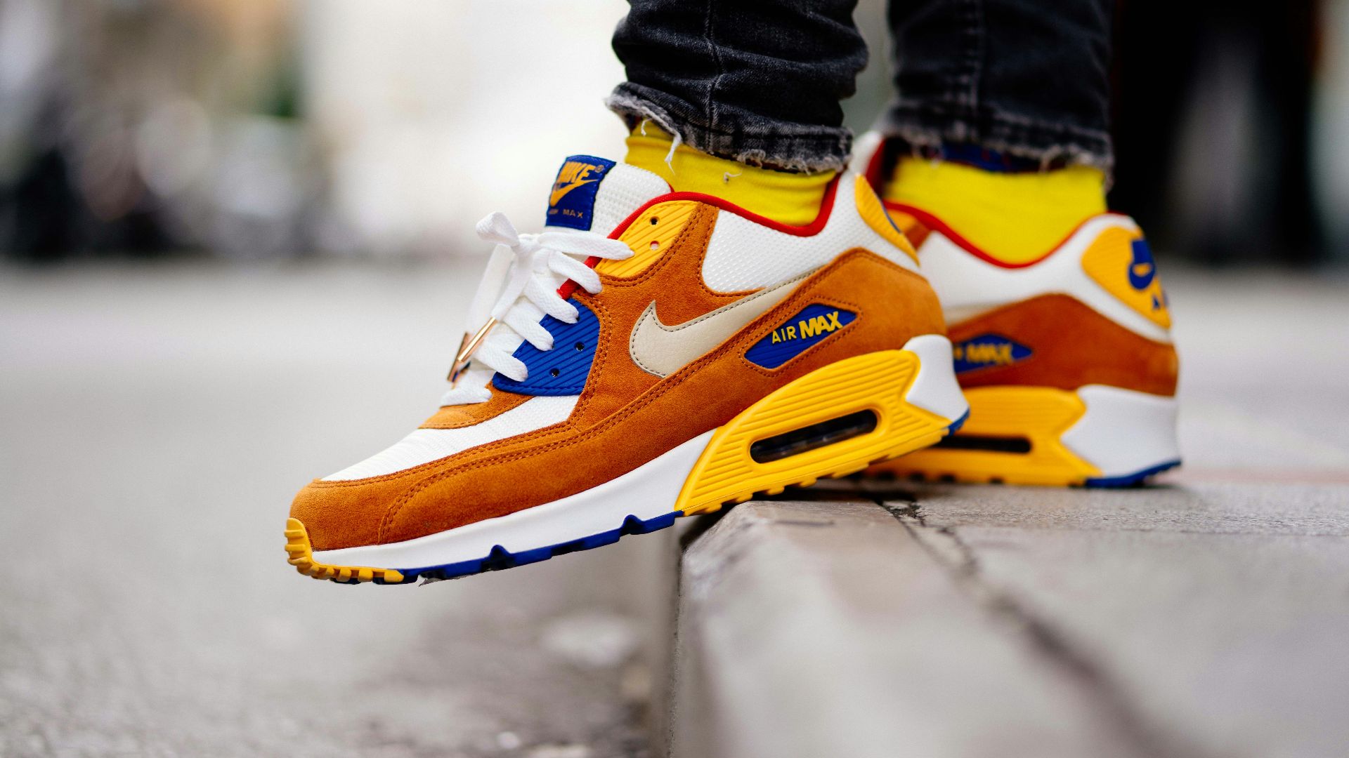 close-up photography of person wears brown-and-white Nike Air Max