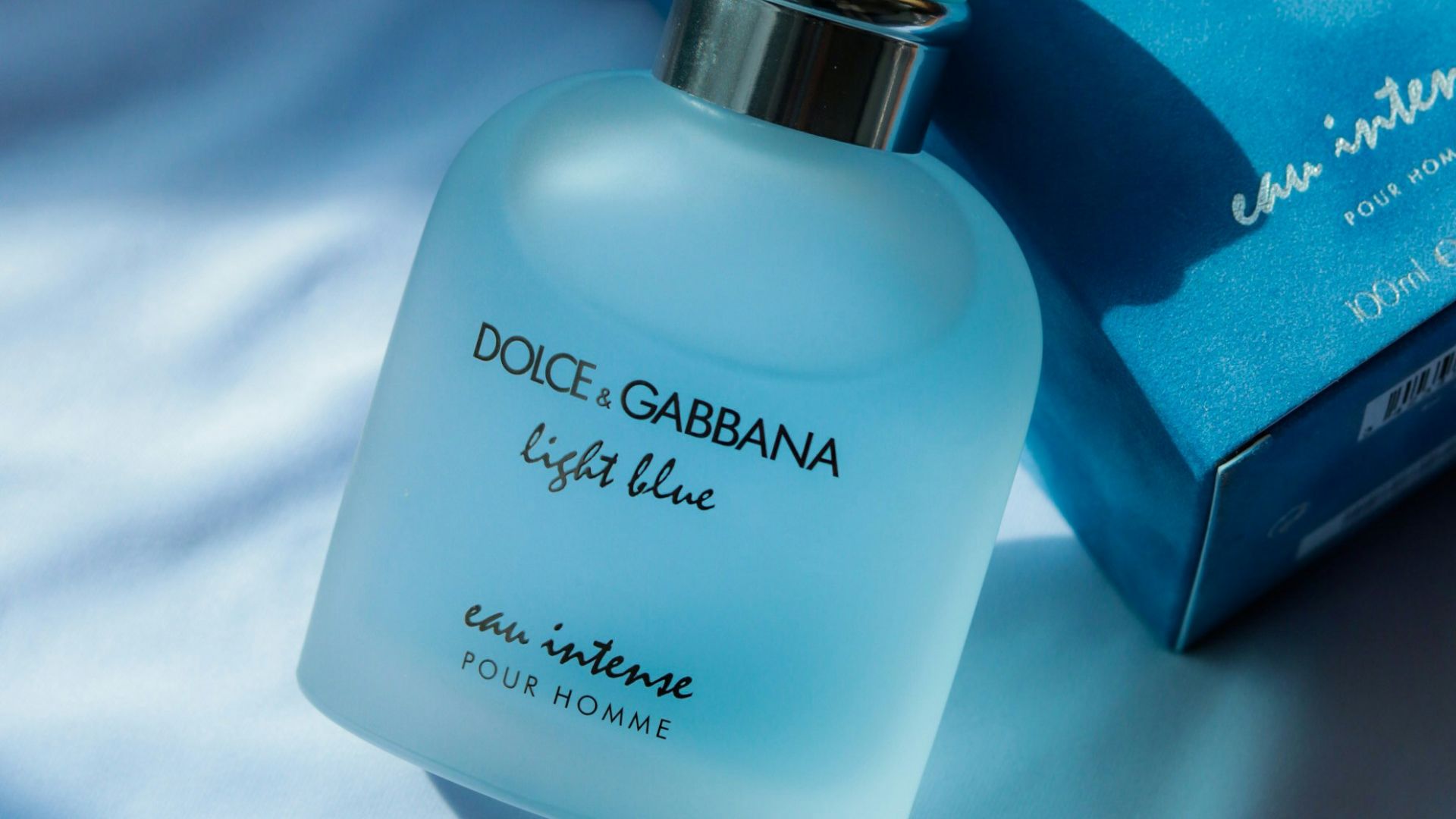 A bottle of dolce garbana light blue next to a box