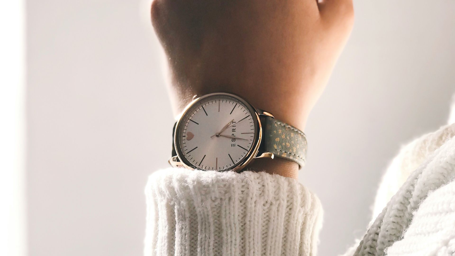 person wearing round silver-colored analog watch