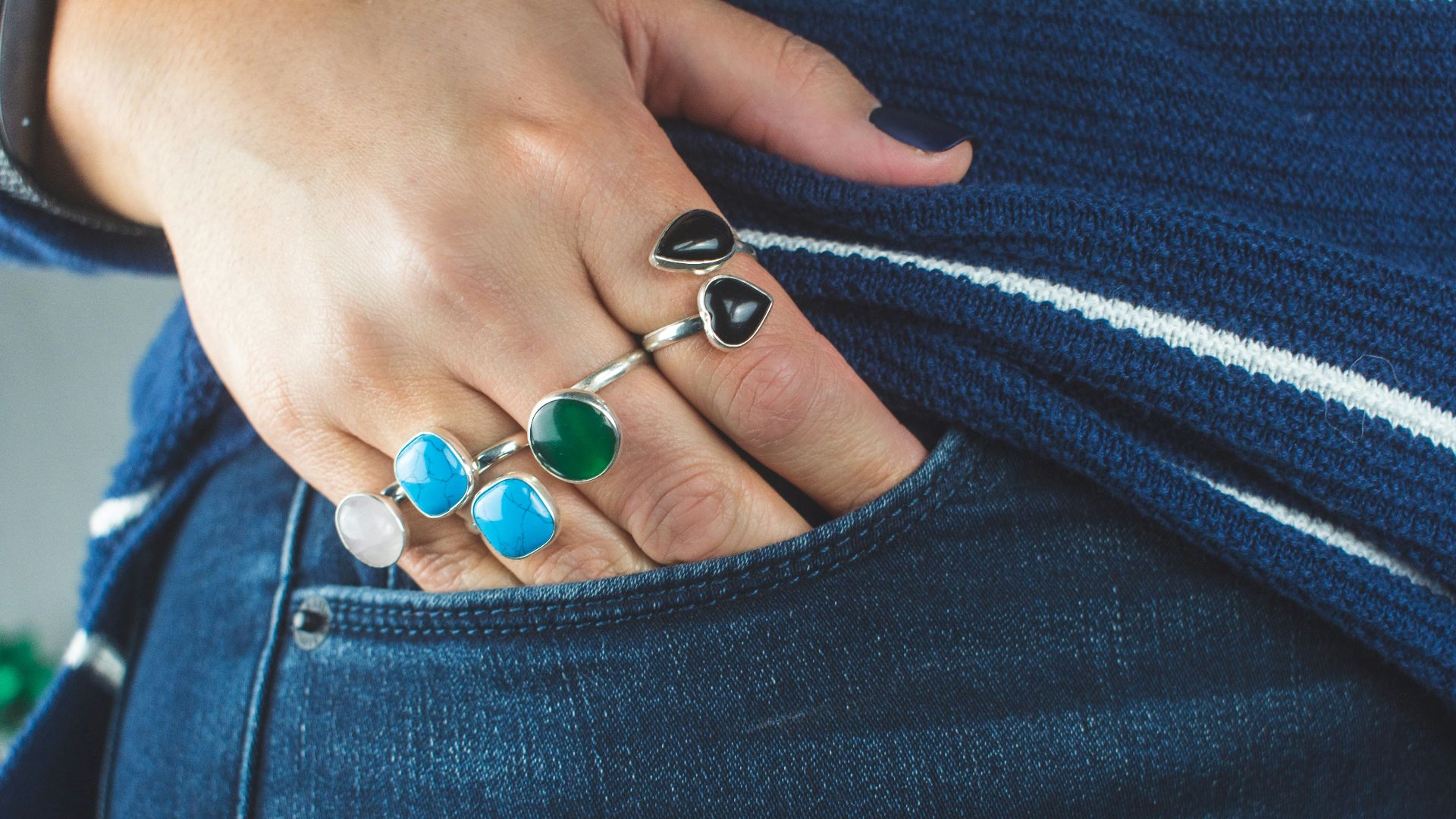 person wearing silver teal and green gemstone ring
