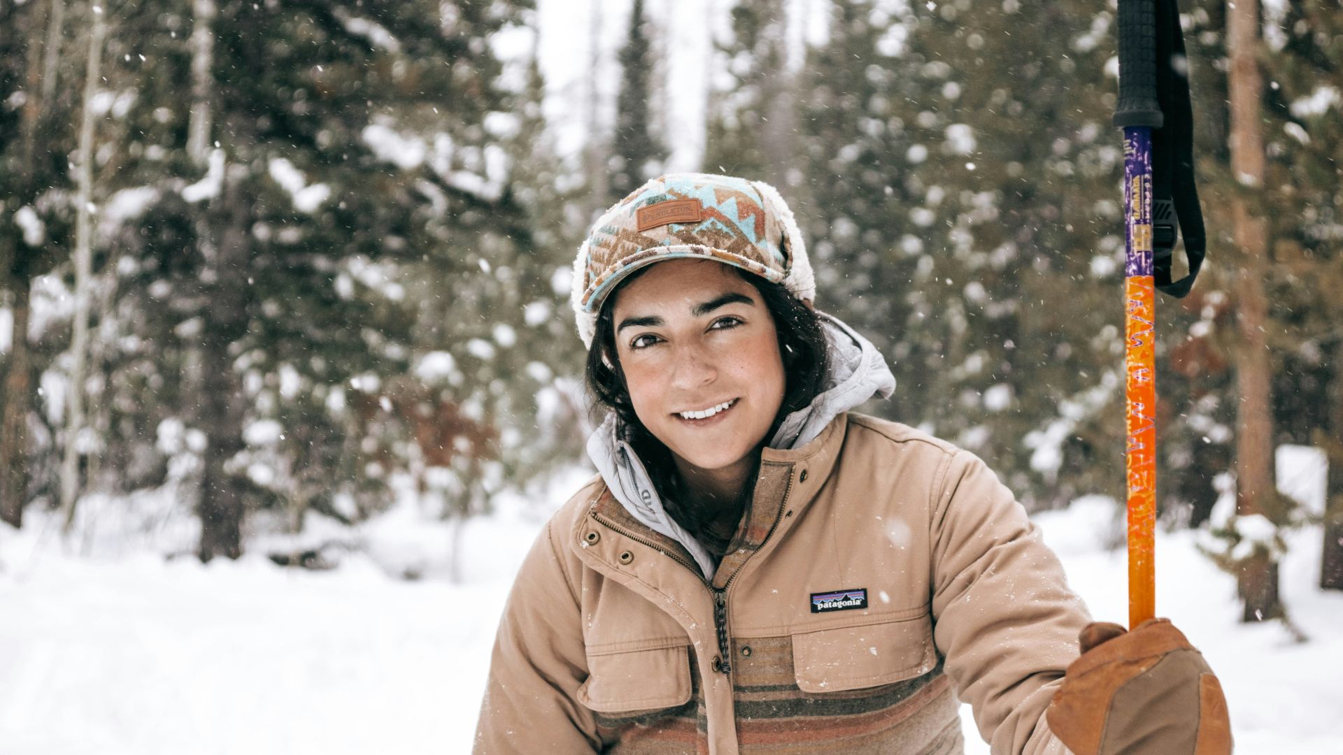 woman in brown jacket standing on snow covered ground during daytime