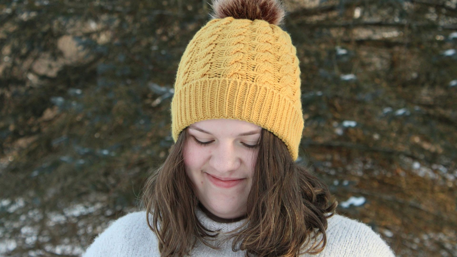 woman in white sweater wearing yellow knit cap
