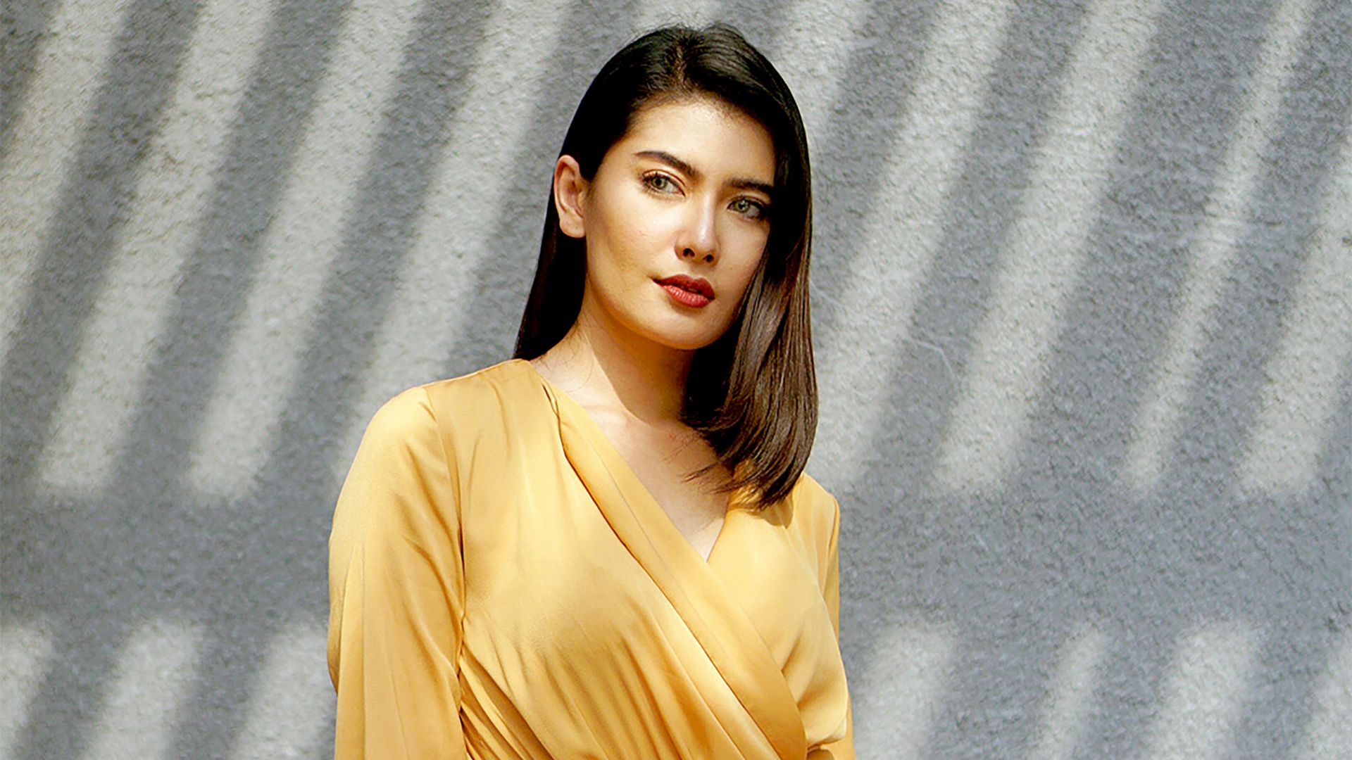 woman in brown long sleeve dress standing beside gray wall