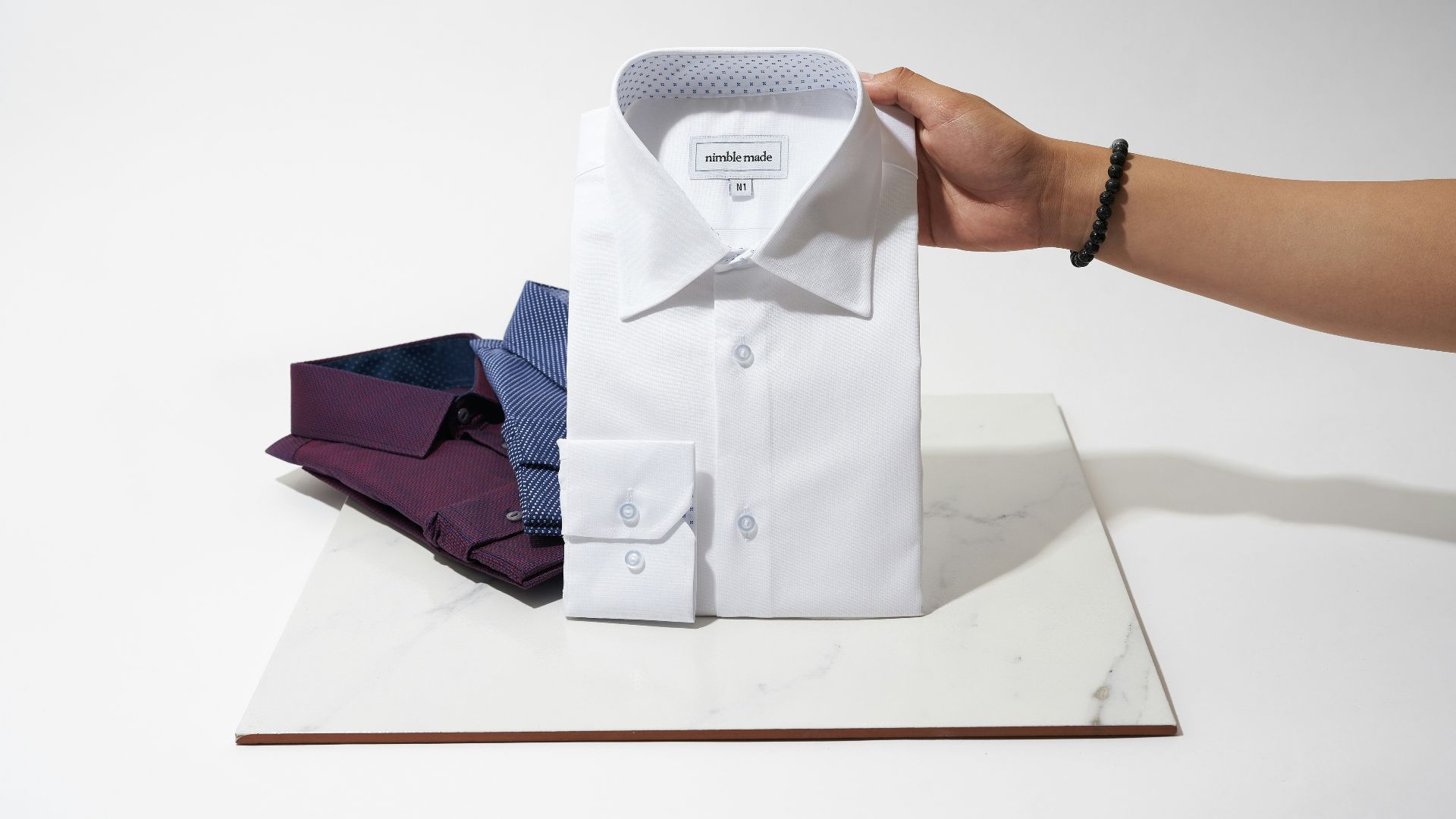 person holding white button up shirt