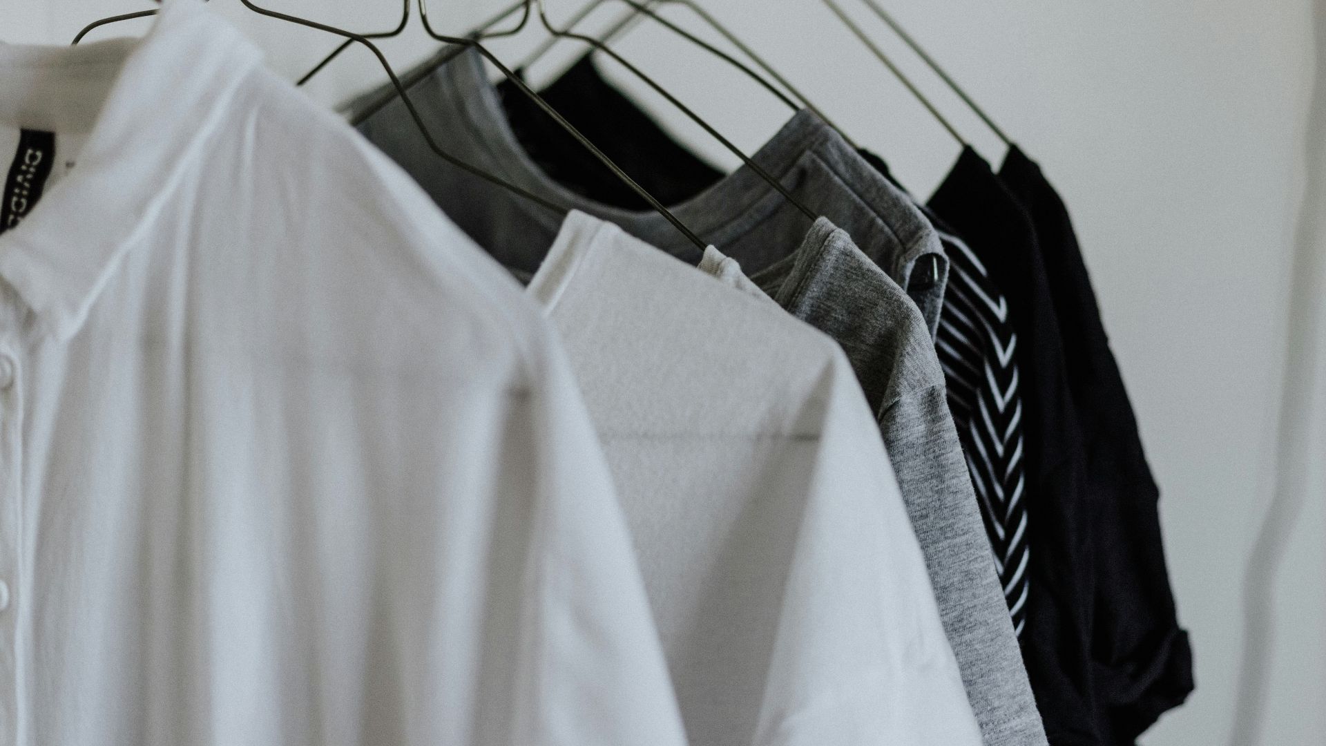 assorted-color shirt hanging beside wall