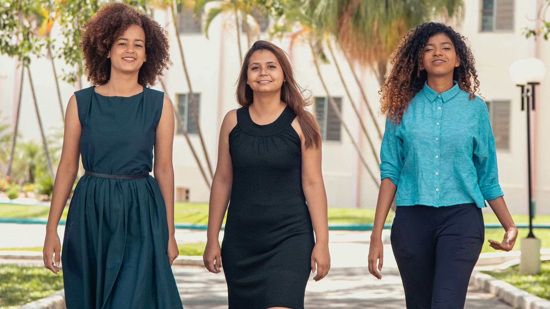 2 women in blue sleeveless dress standing on gray concrete pathway during daytime