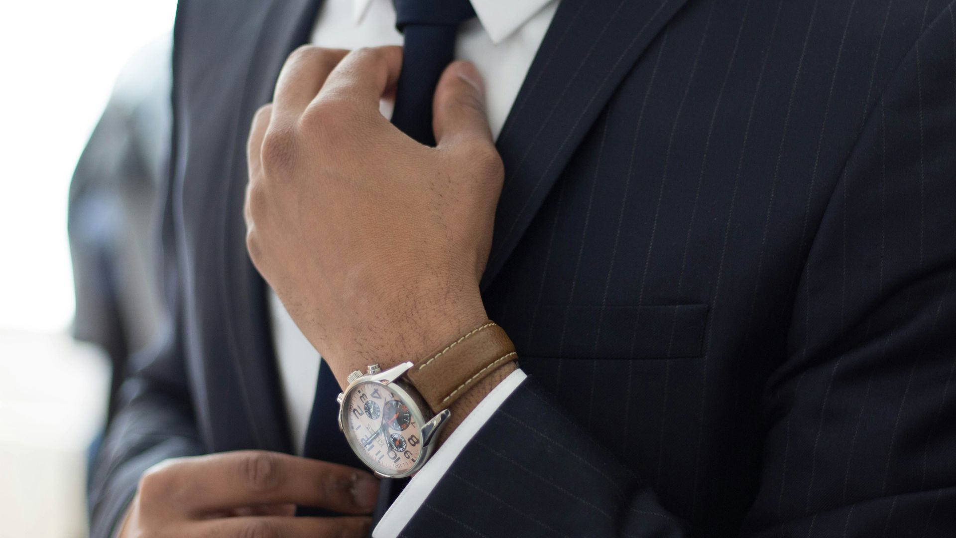 man wearing watch with black suit