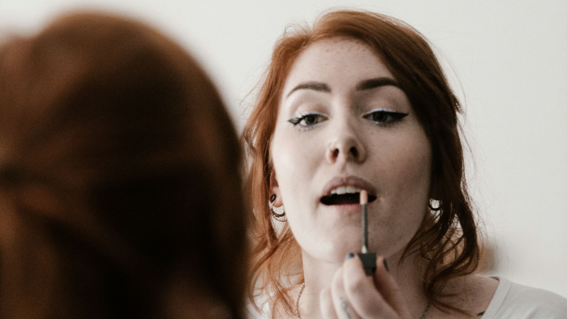 woman putting lipstick on her lips