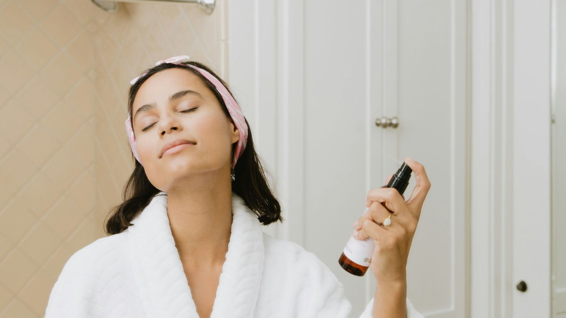 woman in white bathrobe holding smartphone