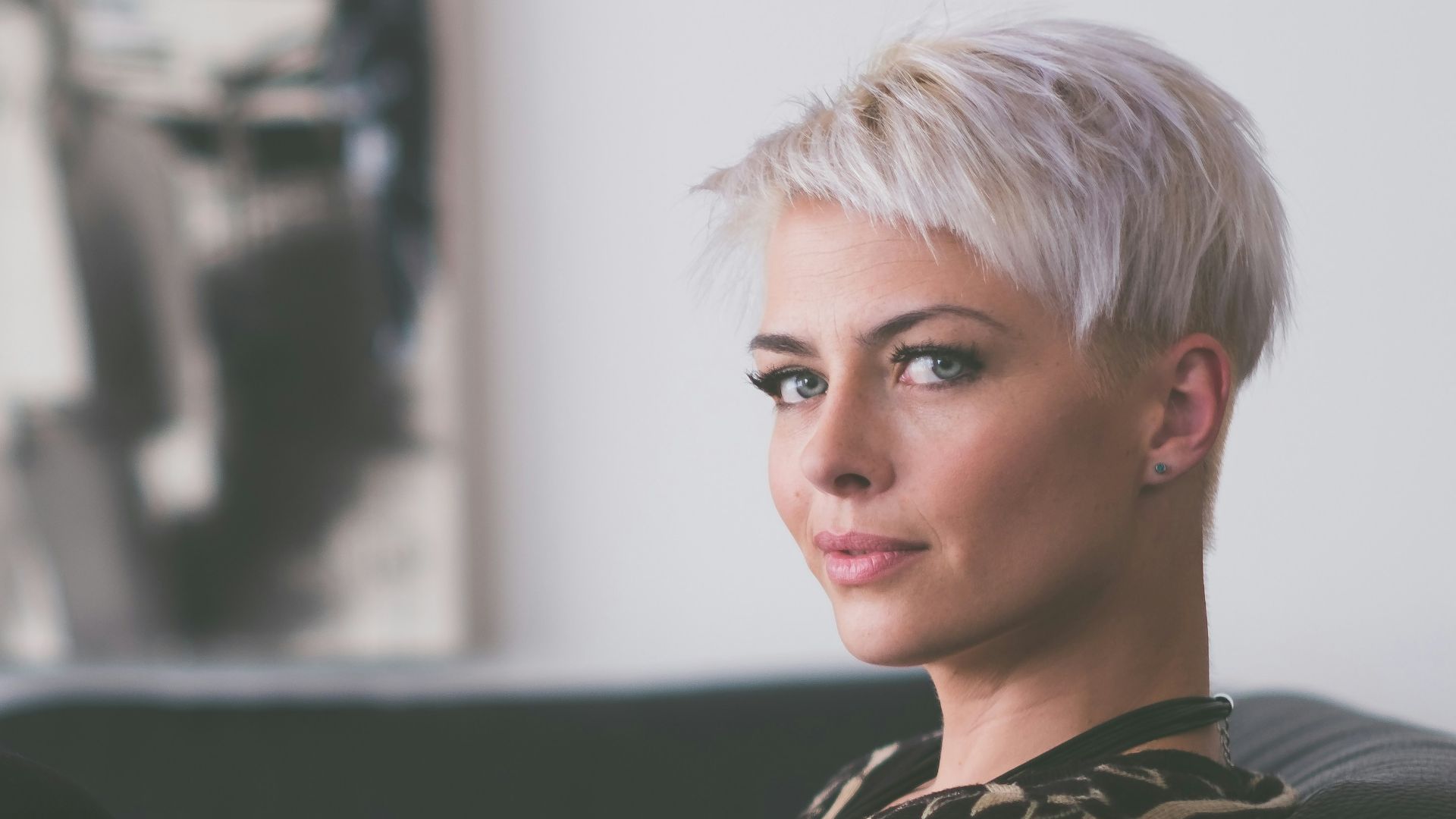 woman sitting on sofa holding eyeglasses