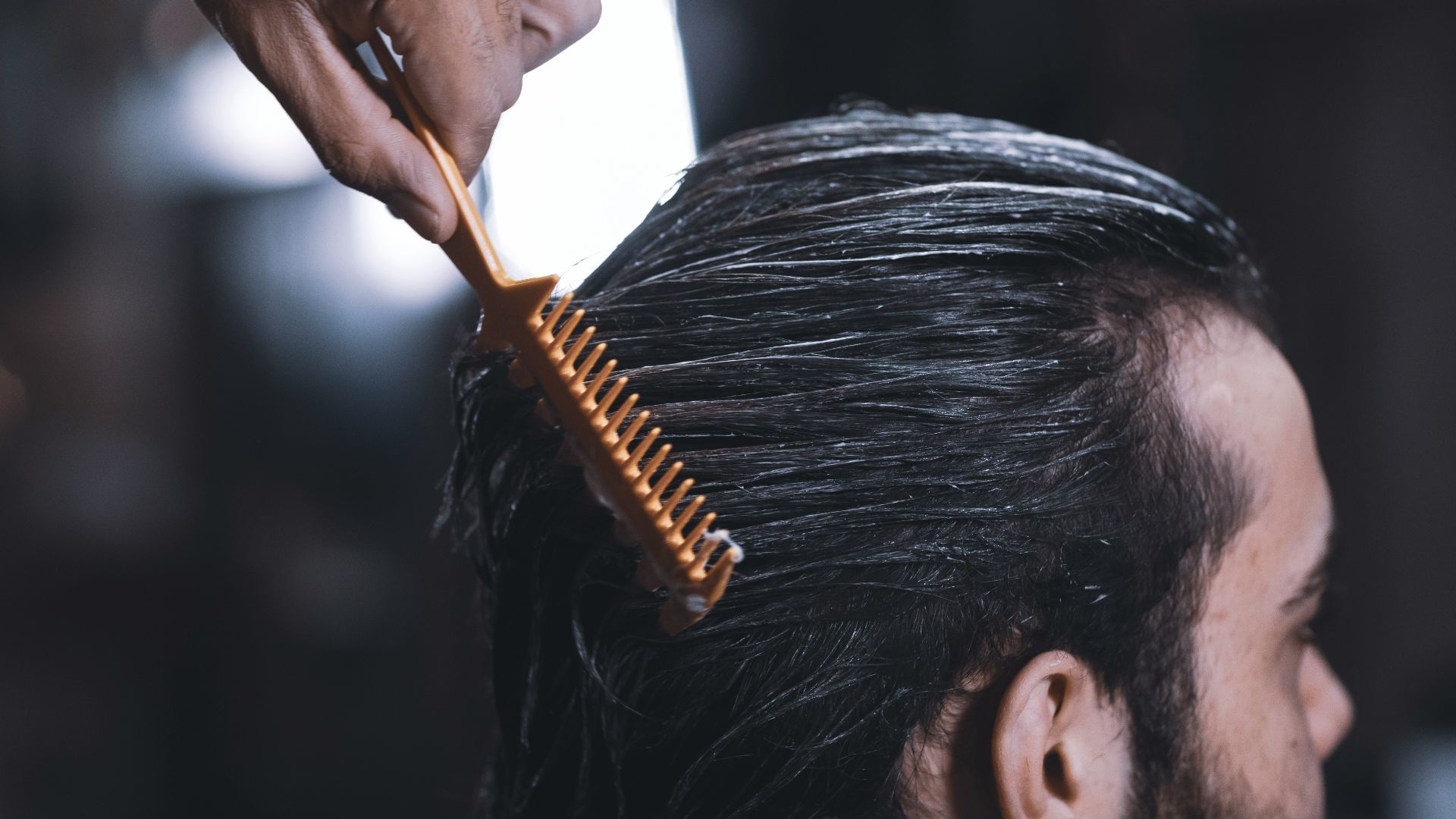 woman in white long sleeve shirt holding brown hair brush