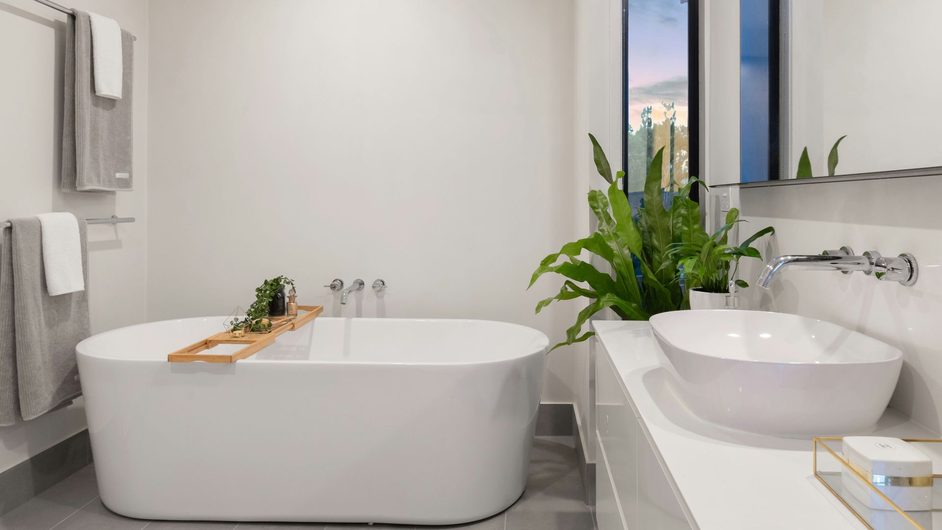 white ceramic bathtub near green potted plant