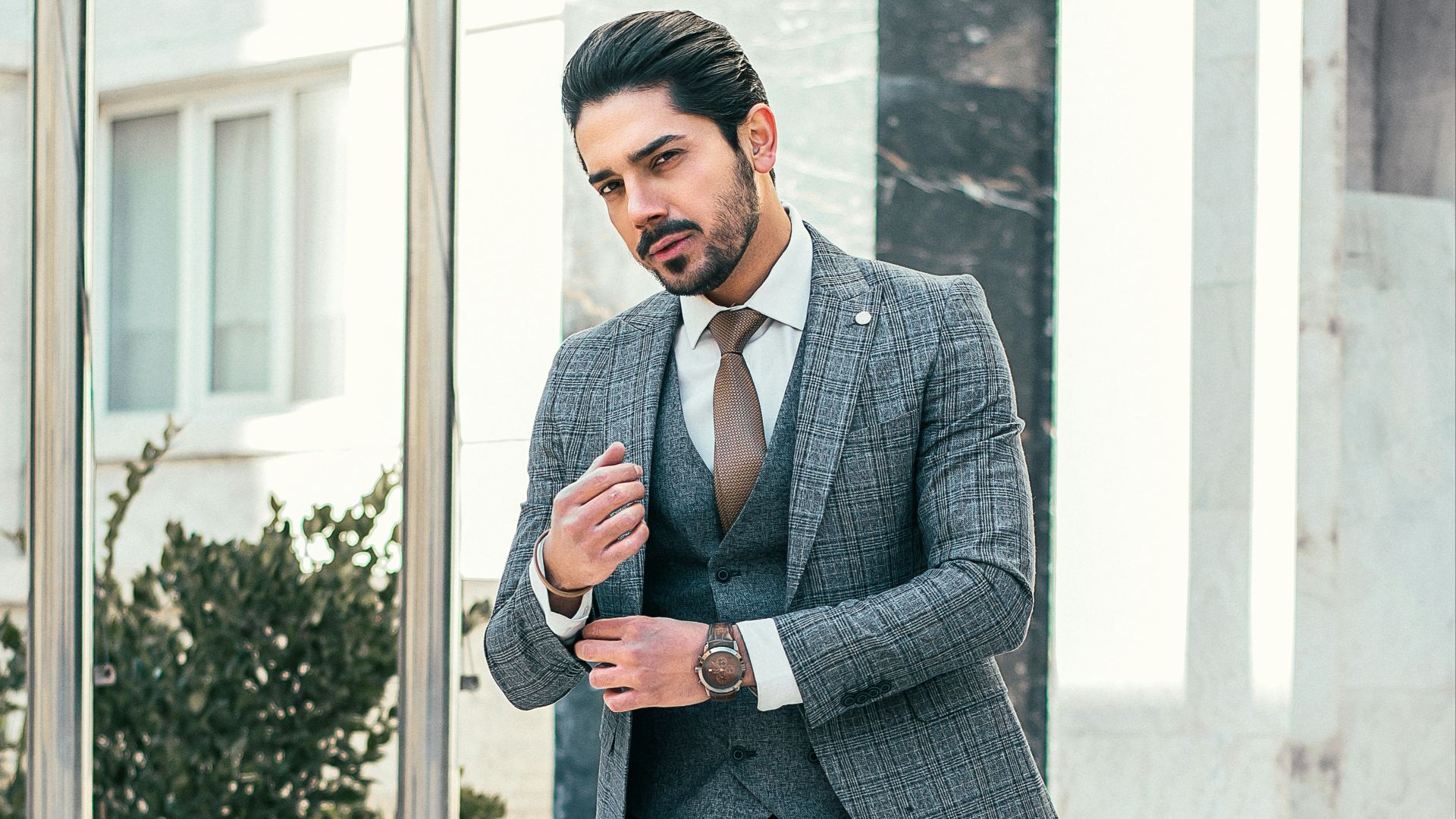 man in gray suit jacket and black pants standing on white staircase