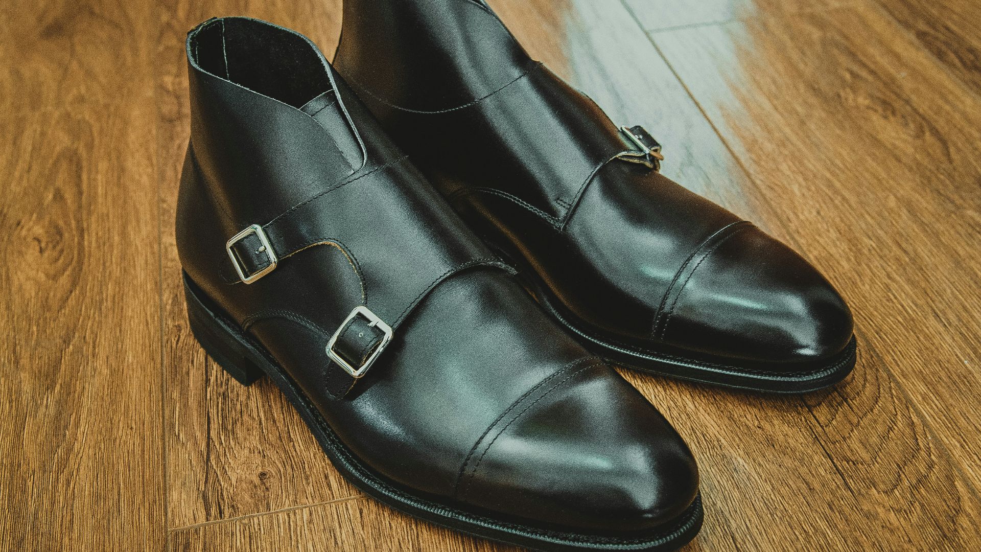 black leather shoes on brown wooden floor