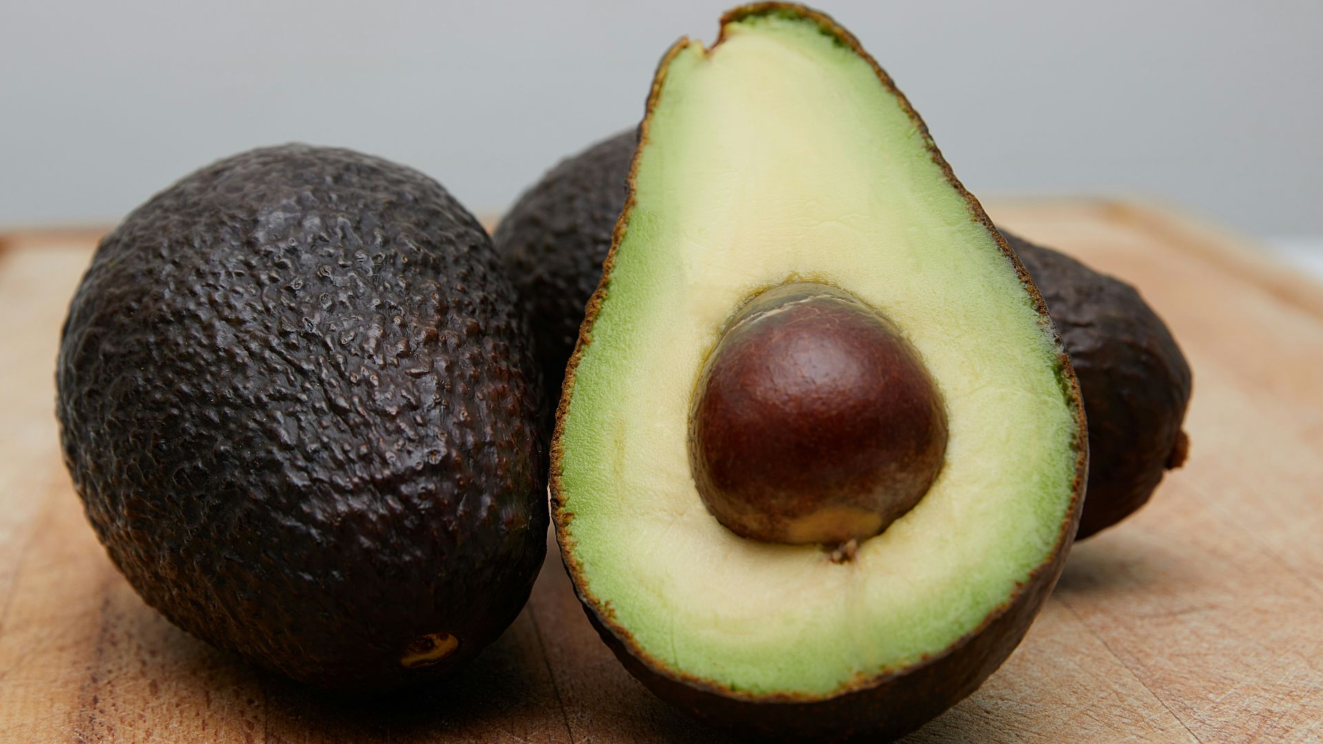 sliced avocado fruit on brown wooden table