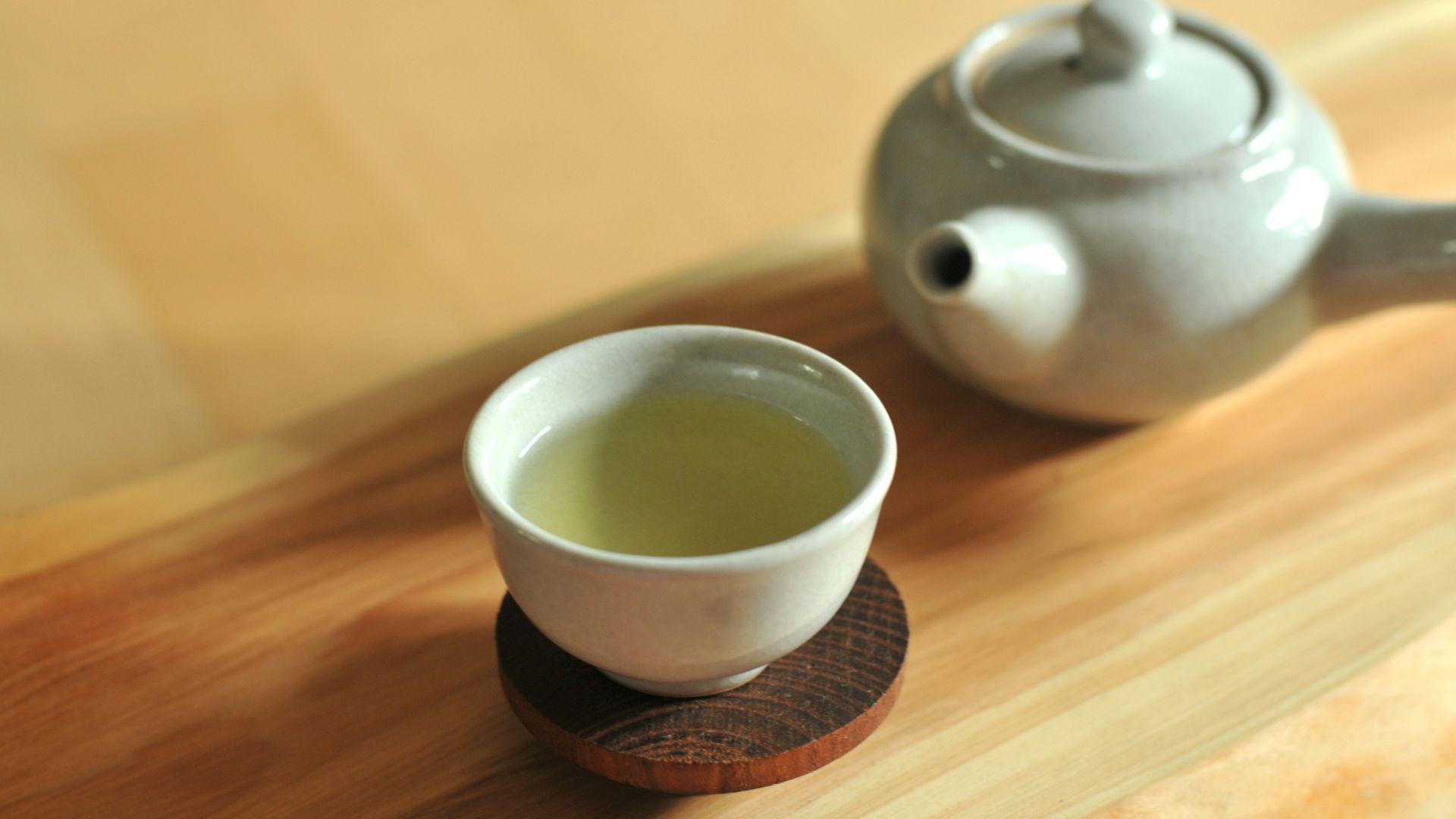 white ceramic teacup on brown wooden table