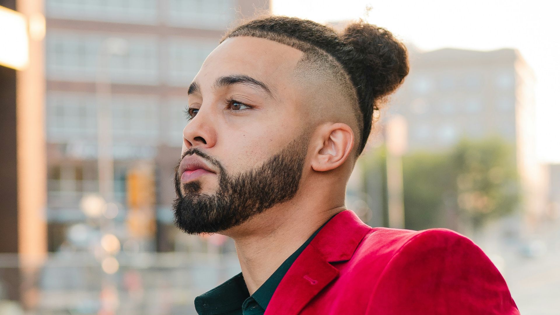 man in red coat standing on road during daytime