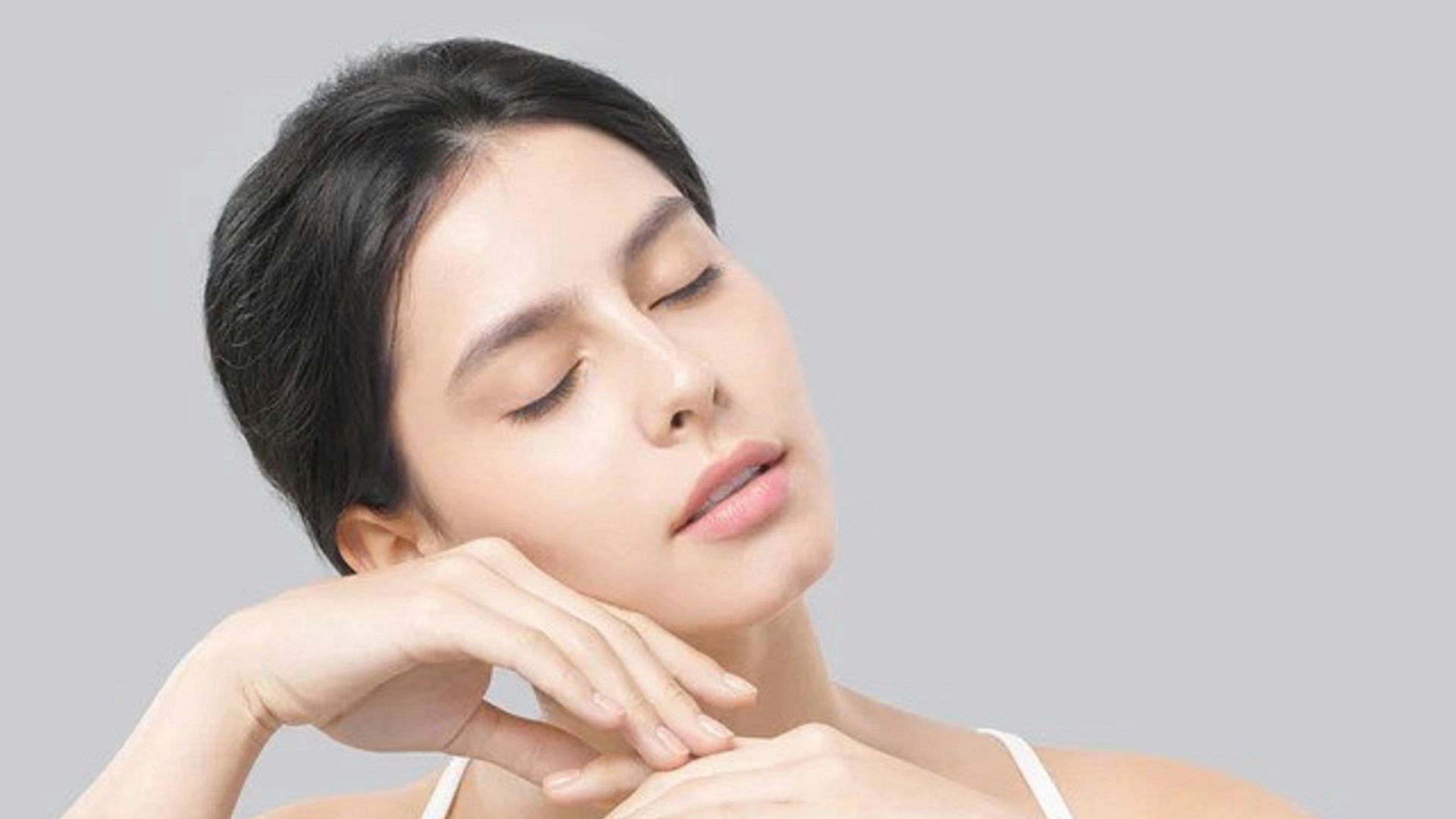 a woman sitting at a table with a hair dryer
