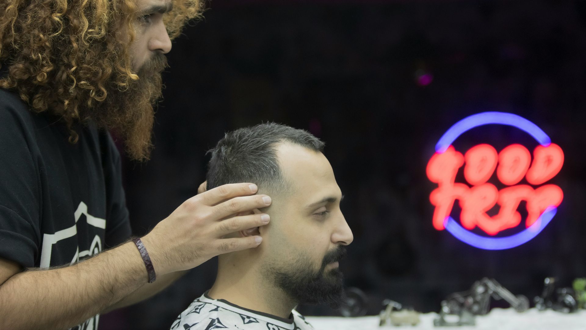 a man getting his hair cut at a barber shop