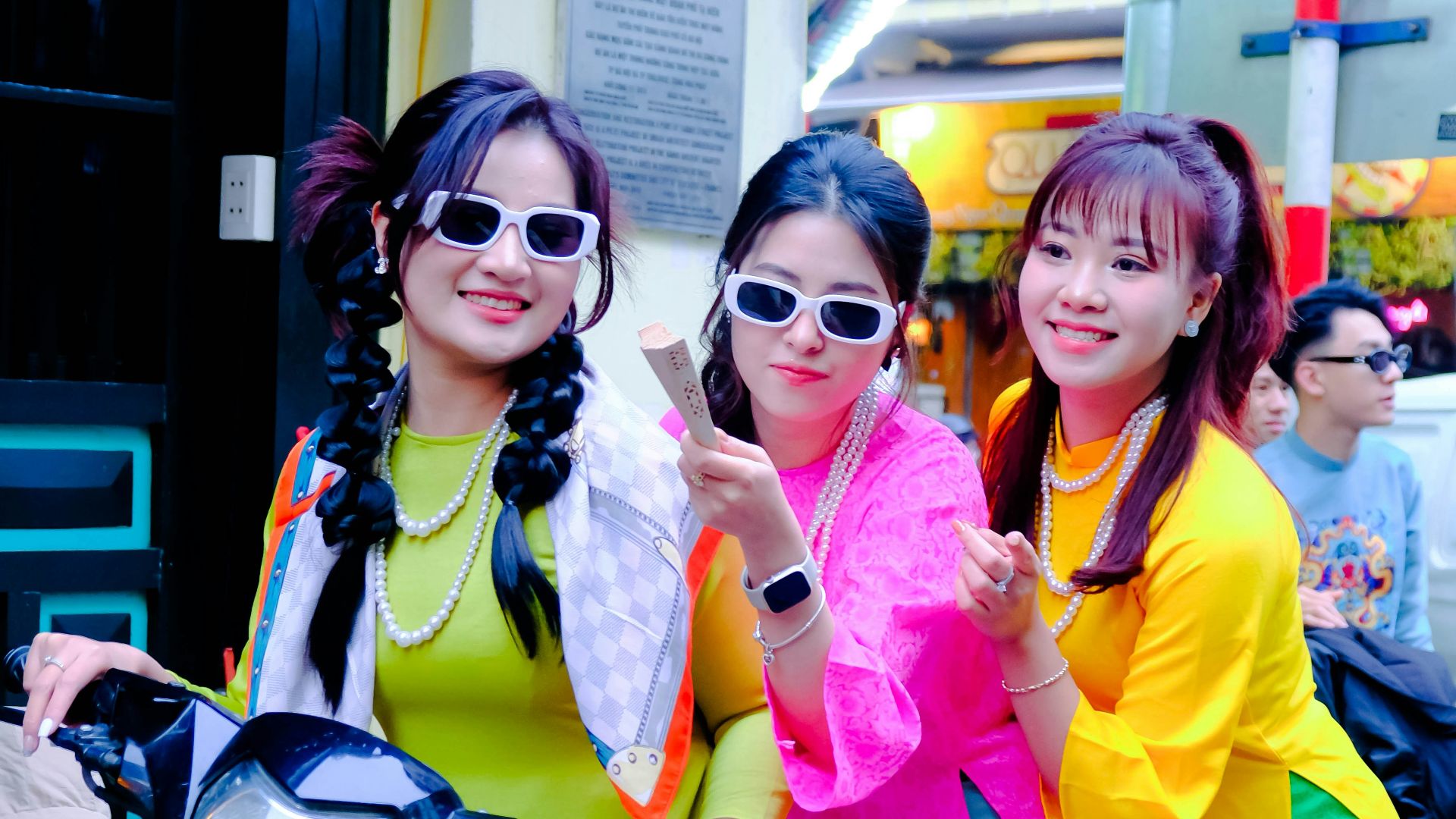three women are posing for a picture on a motorcycle