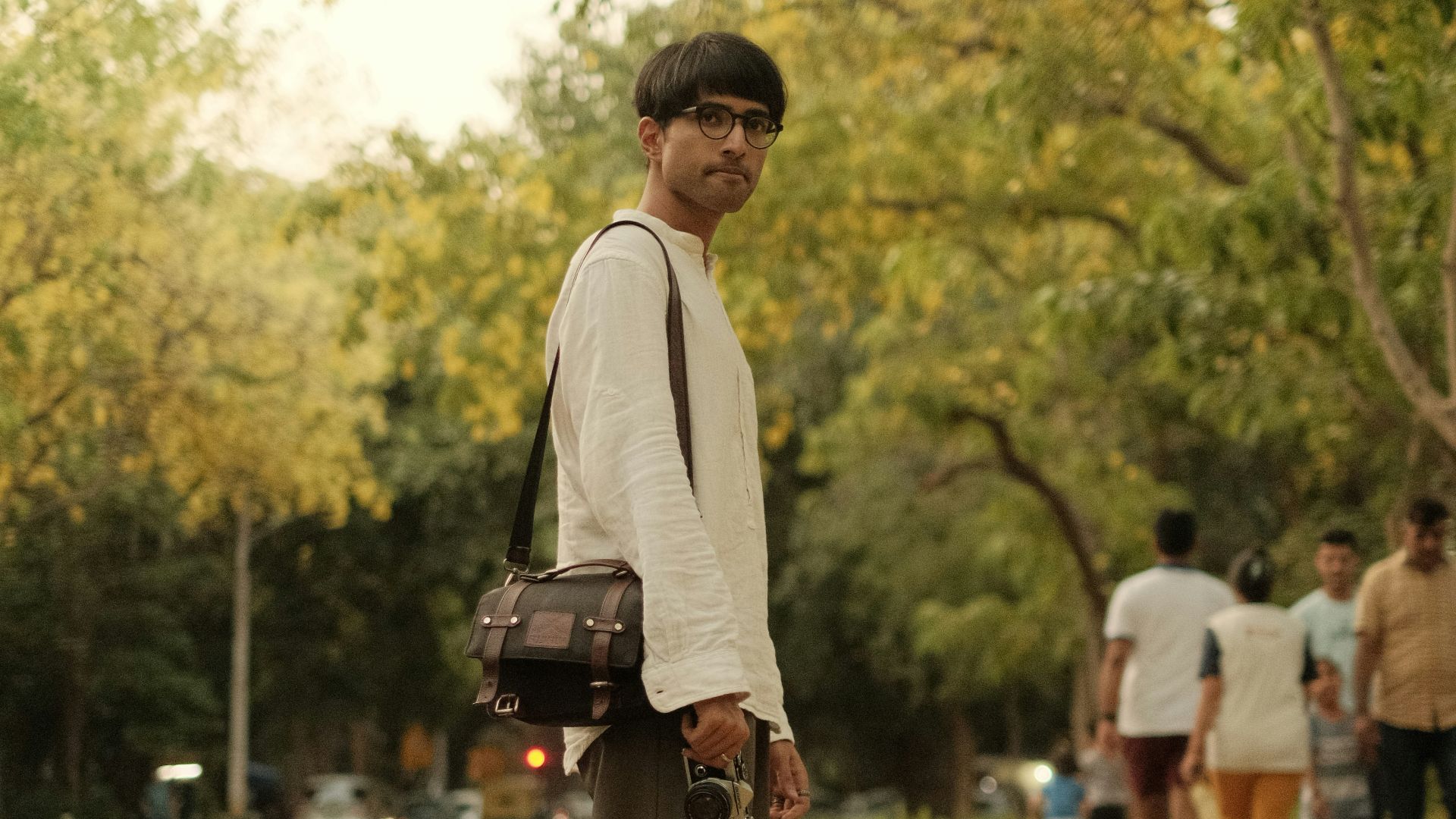 a man standing on the side of a road holding a camera