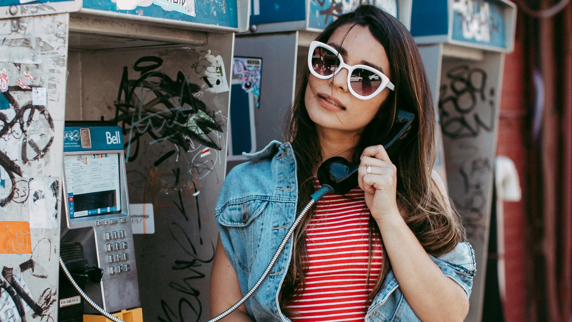 woman in blue and white striped shirt and black skirt wearing sunglasses