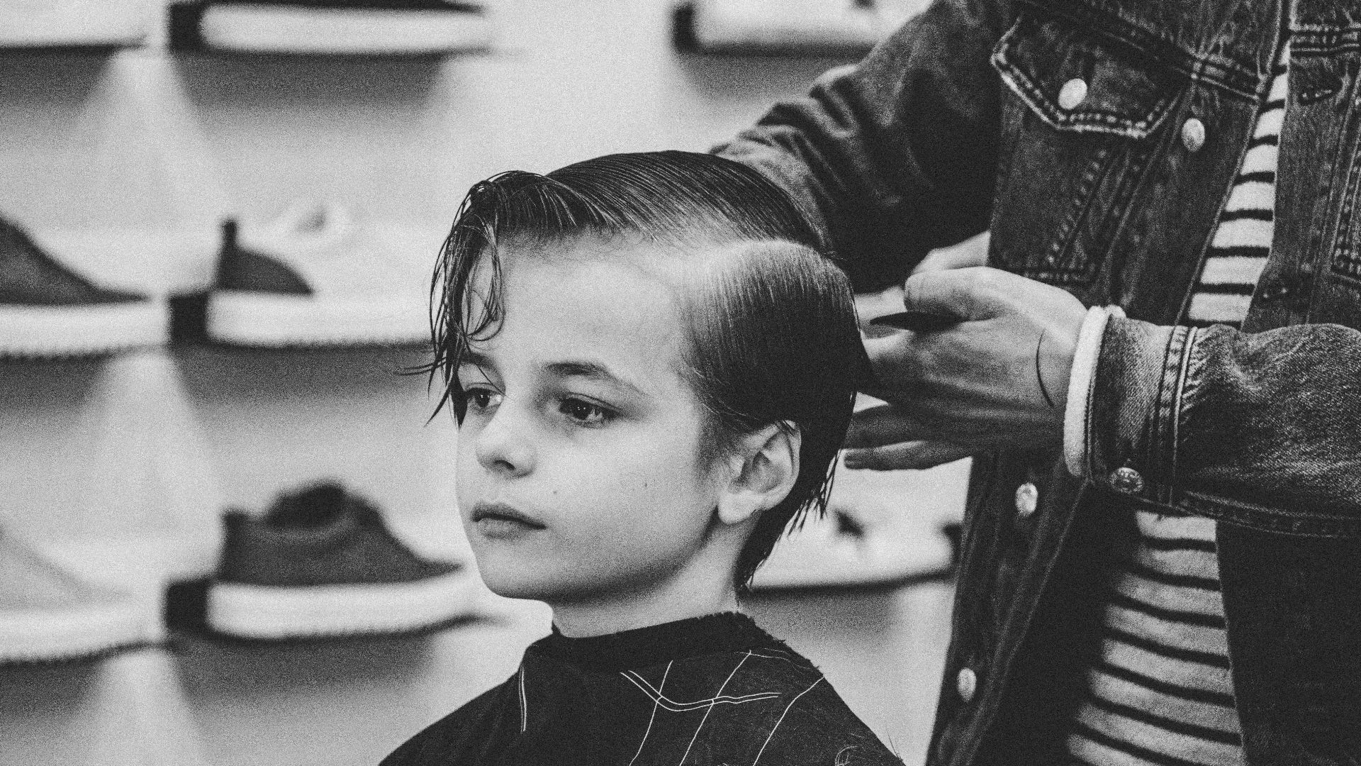 greyscale photo of boy having a haircut