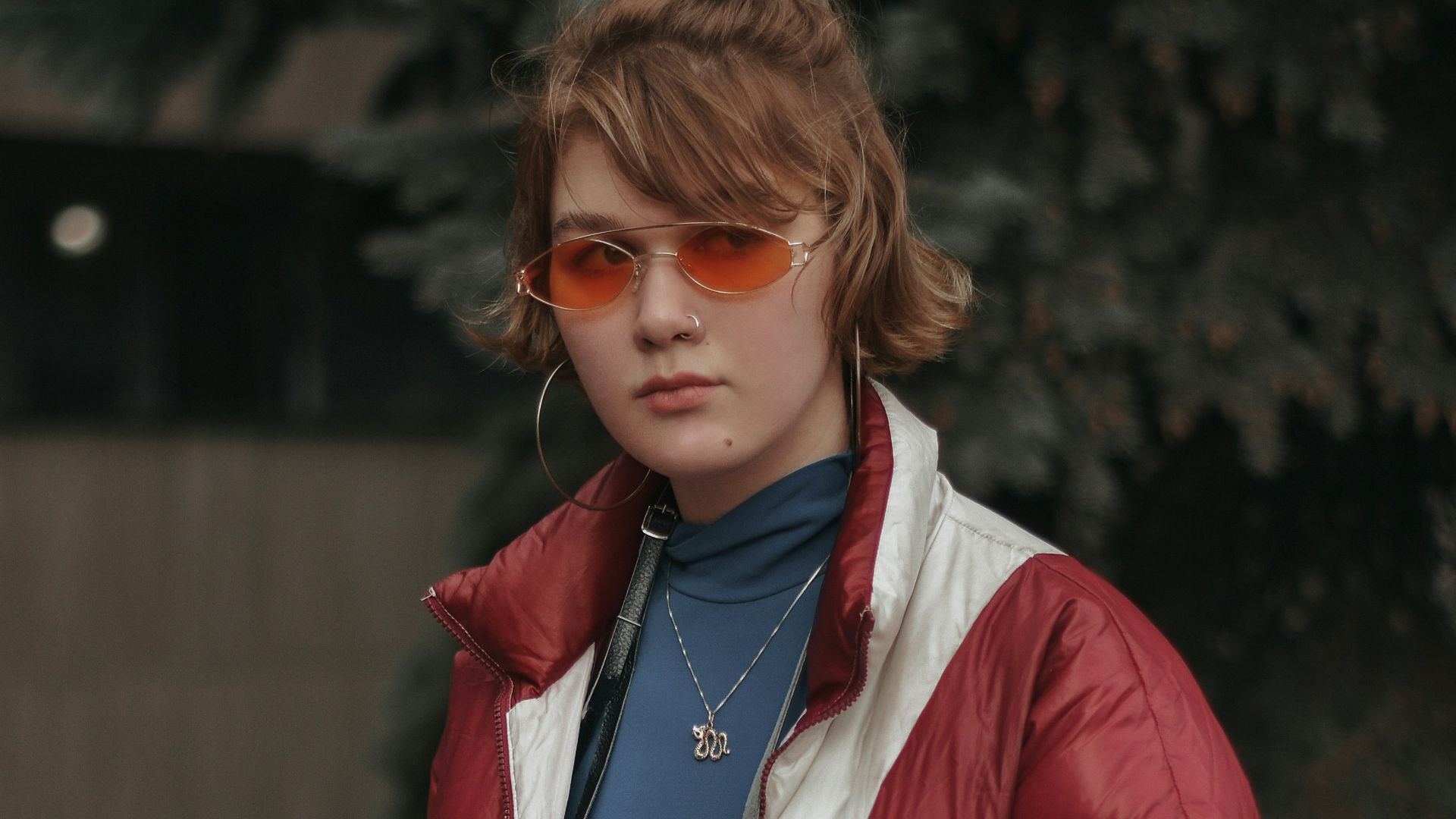 woman in blue jacket holding black camera