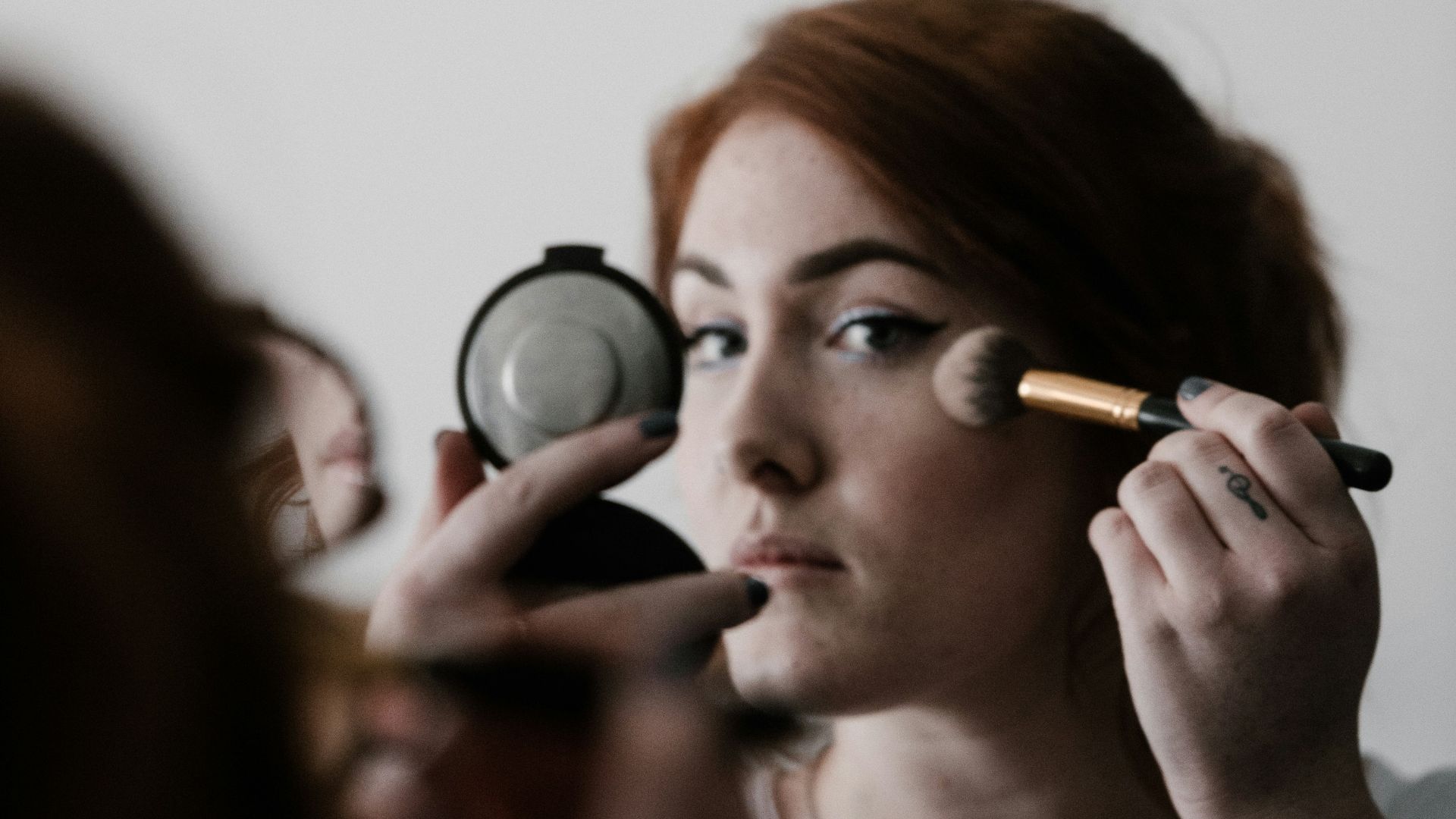 woman doing makeup infront of mirror