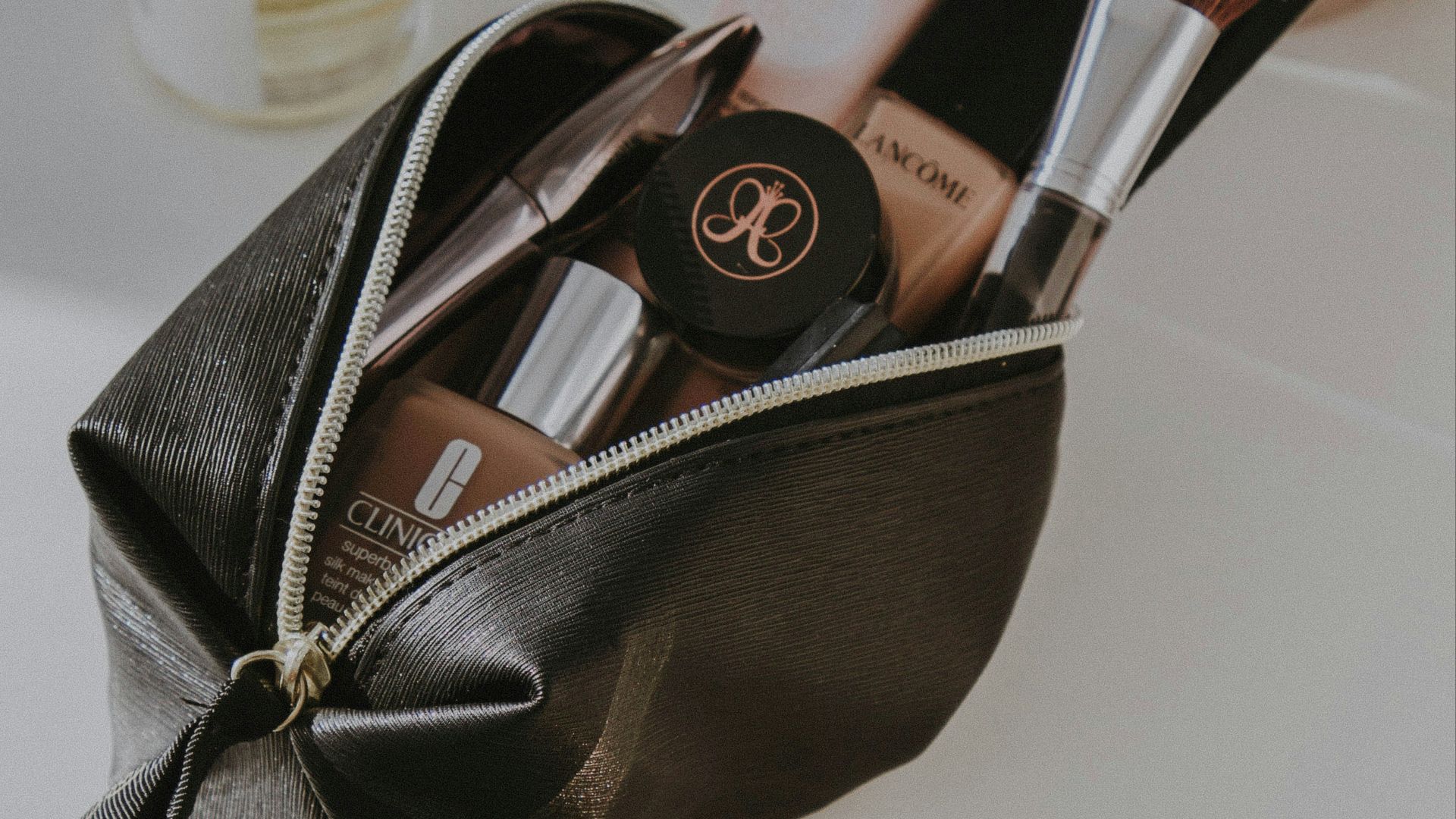 black leather bag with makeup brushes and makeup brushes