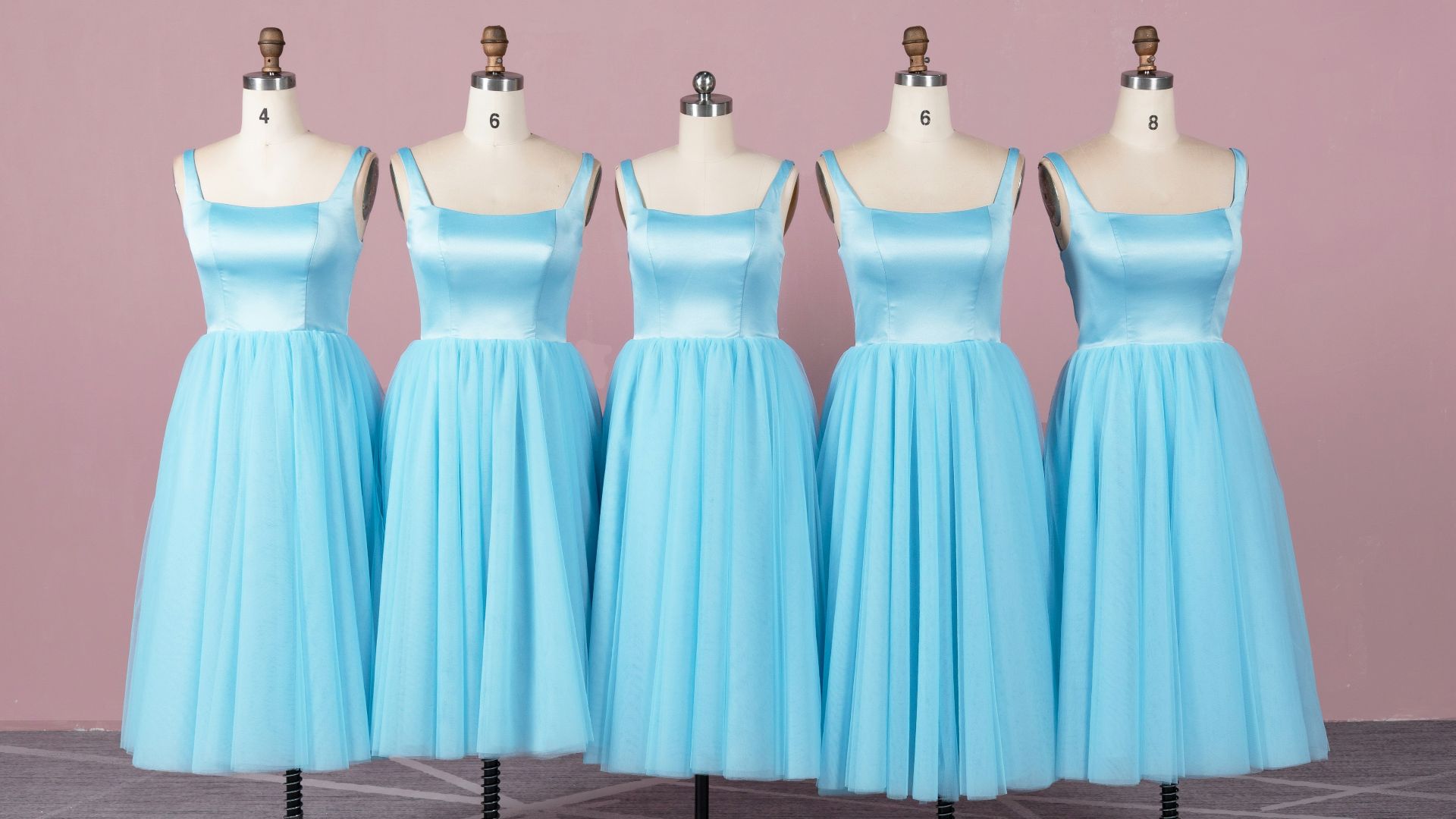 a line of blue bridesmaid dresses on mannequins