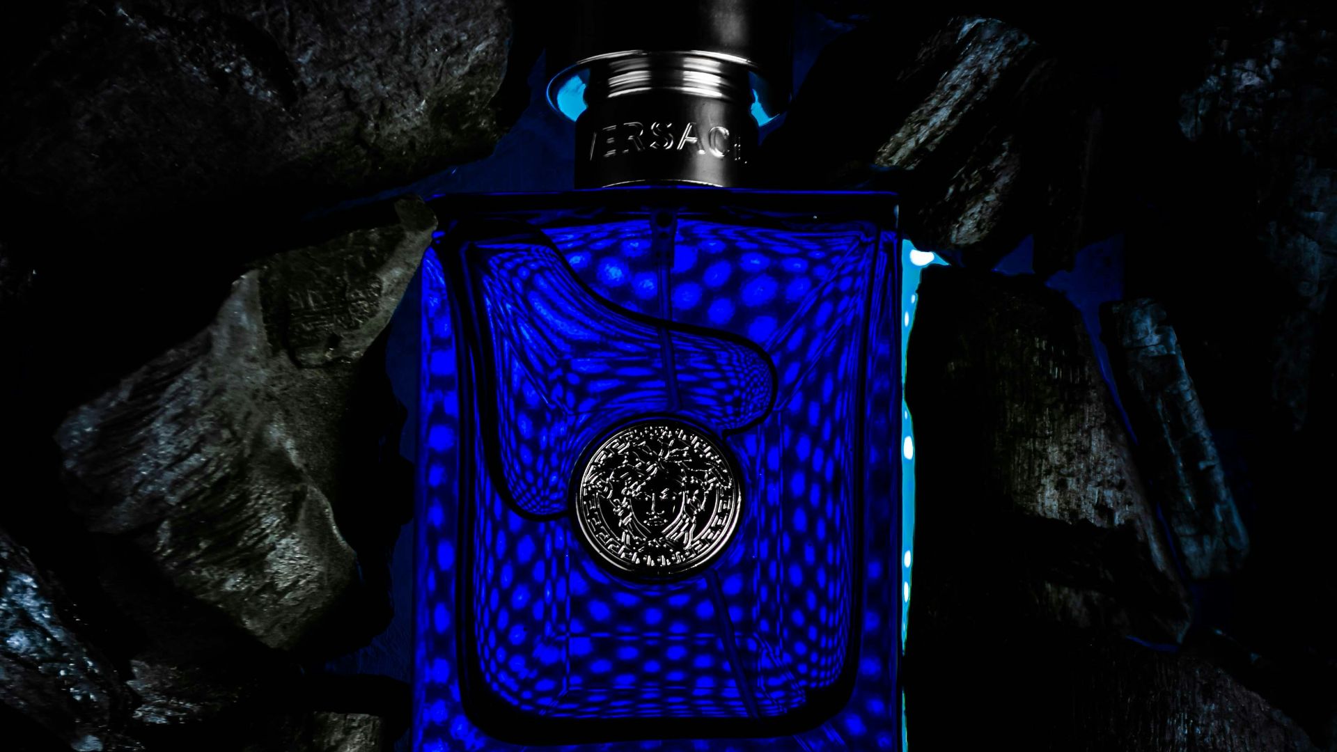 a blue bottle sitting on top of a pile of rocks